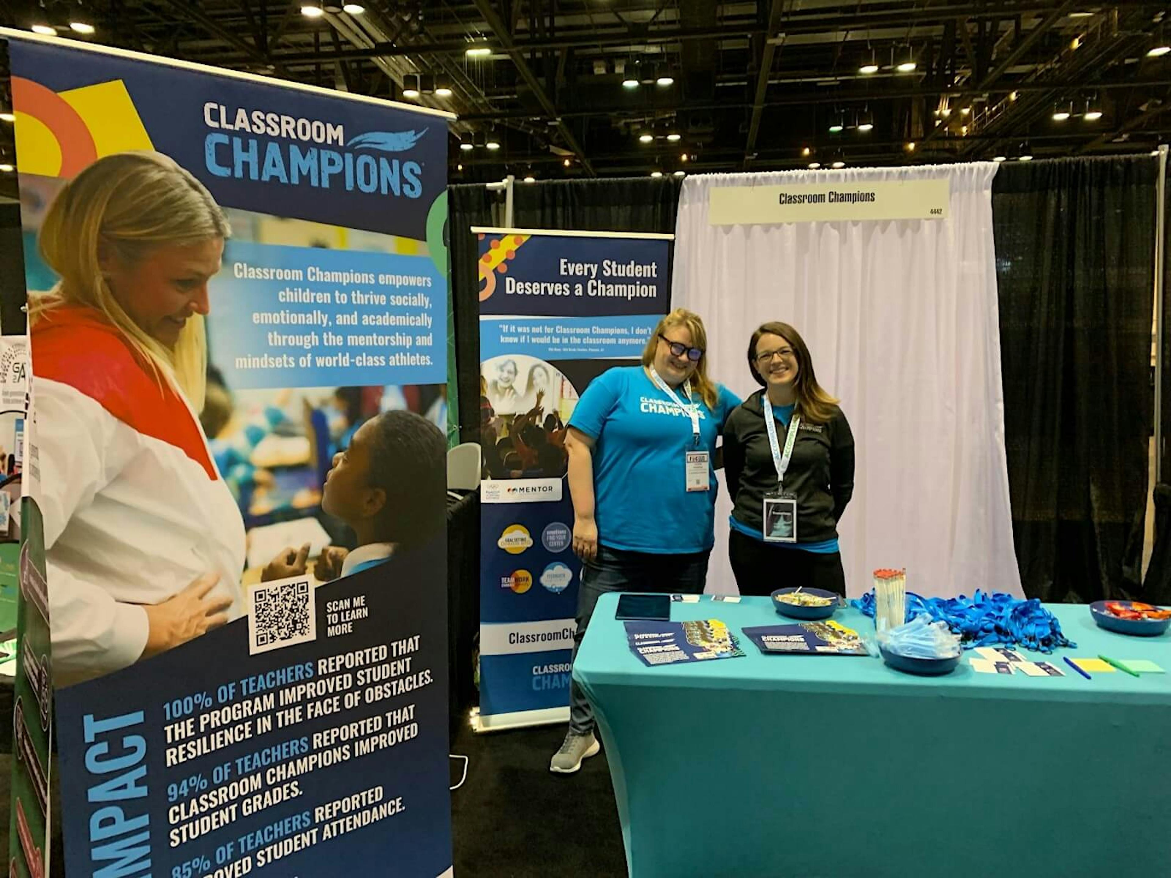 Two Classroom Champions workers at a display booth