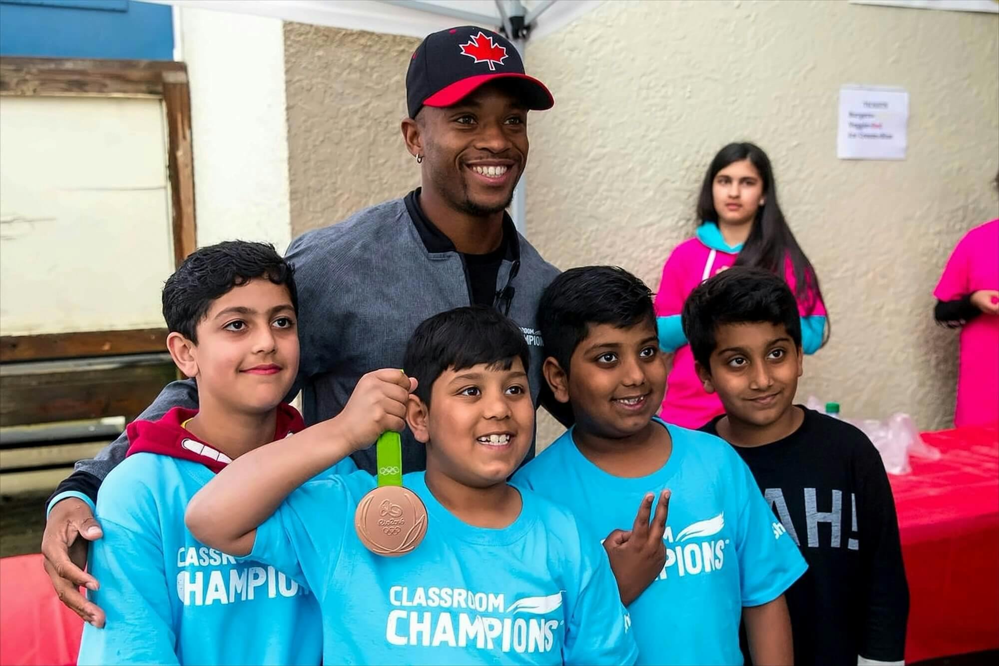 A group of photos pose with an athlete while holding his medal