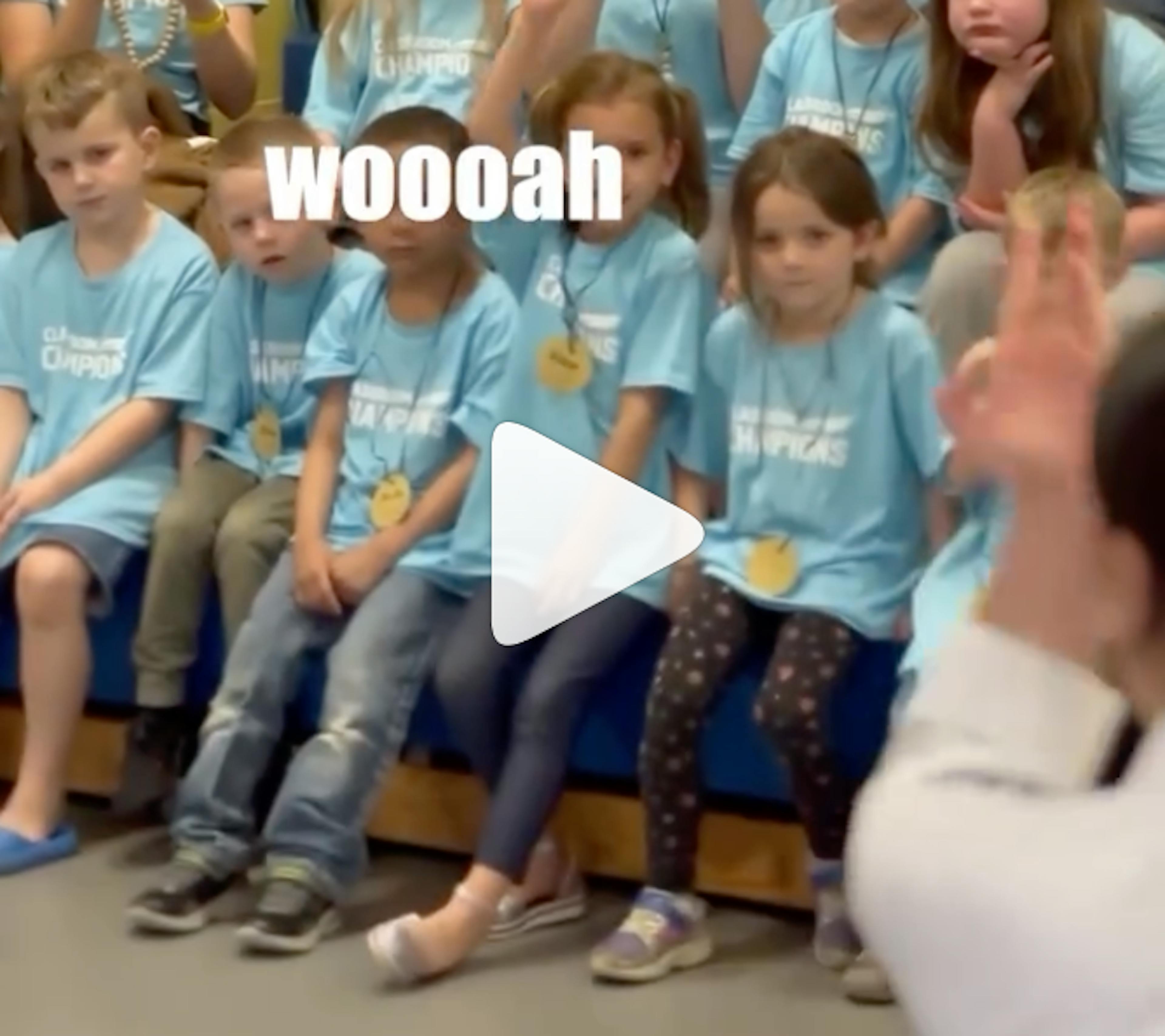 A group of kids overlaid with a 'play' button and the text 'woooah'