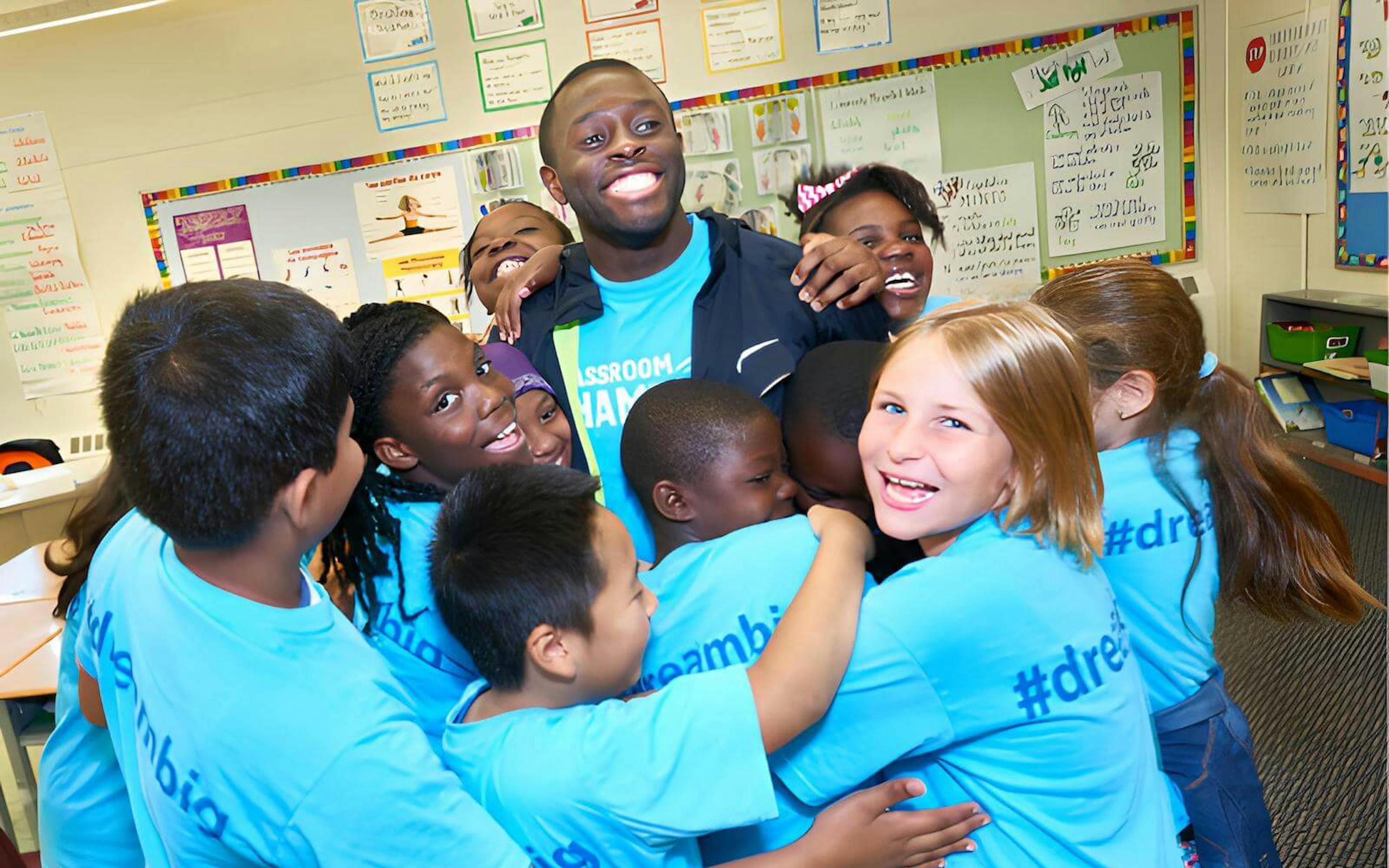 Athlete and group of Classroom Champions participants share a group hug