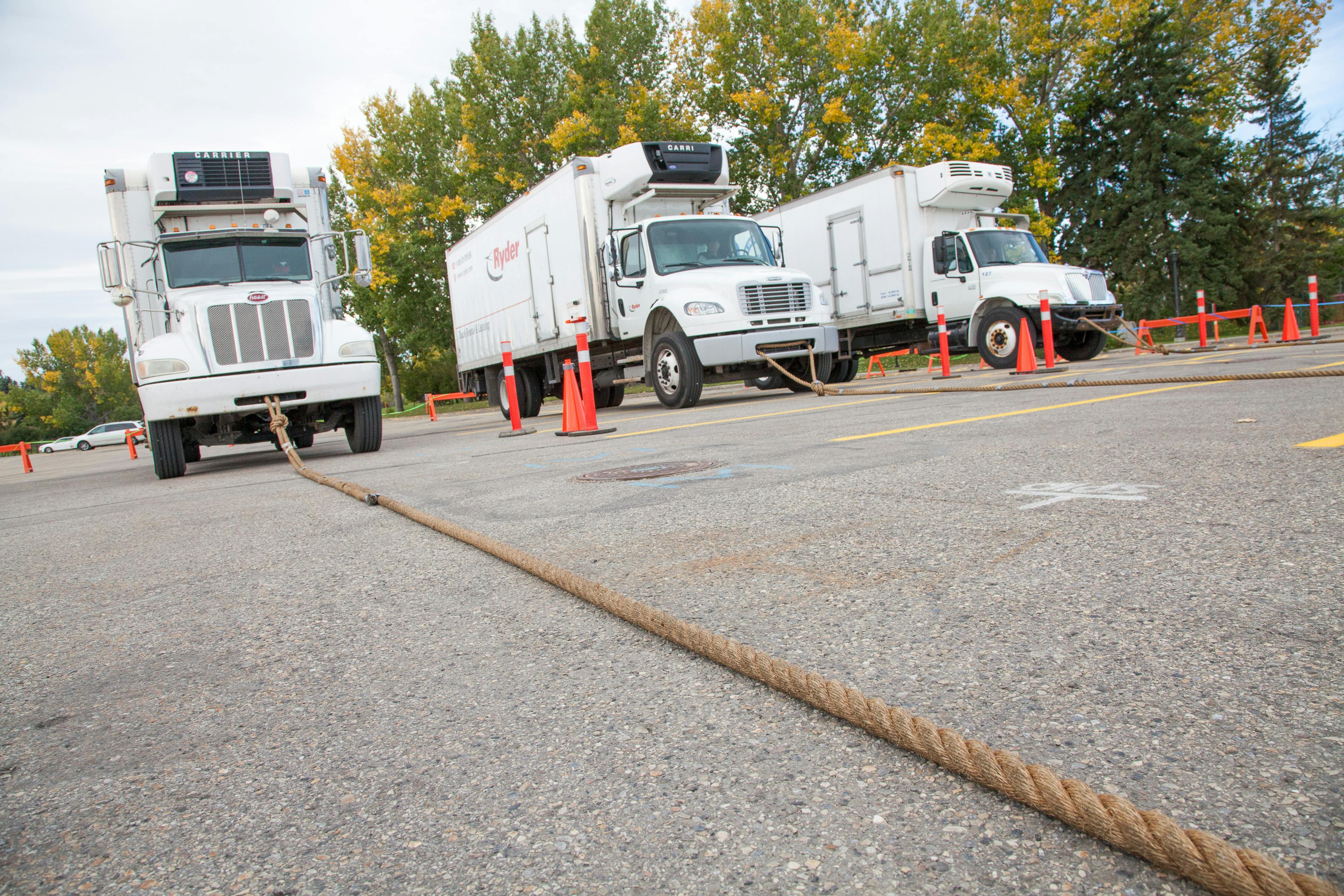 three trucks with ropes attached