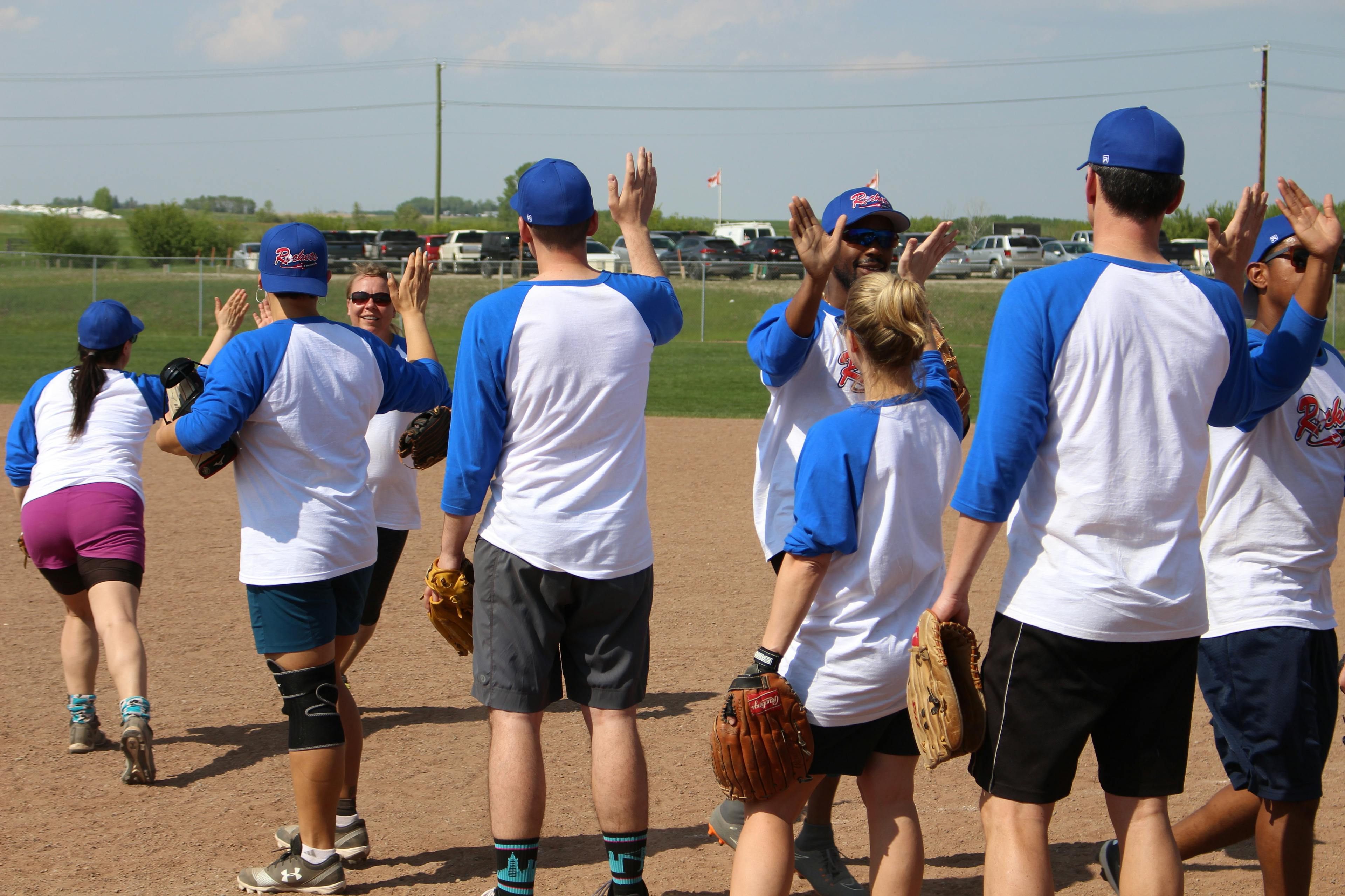 a team high fiving at slo-pitch tournament