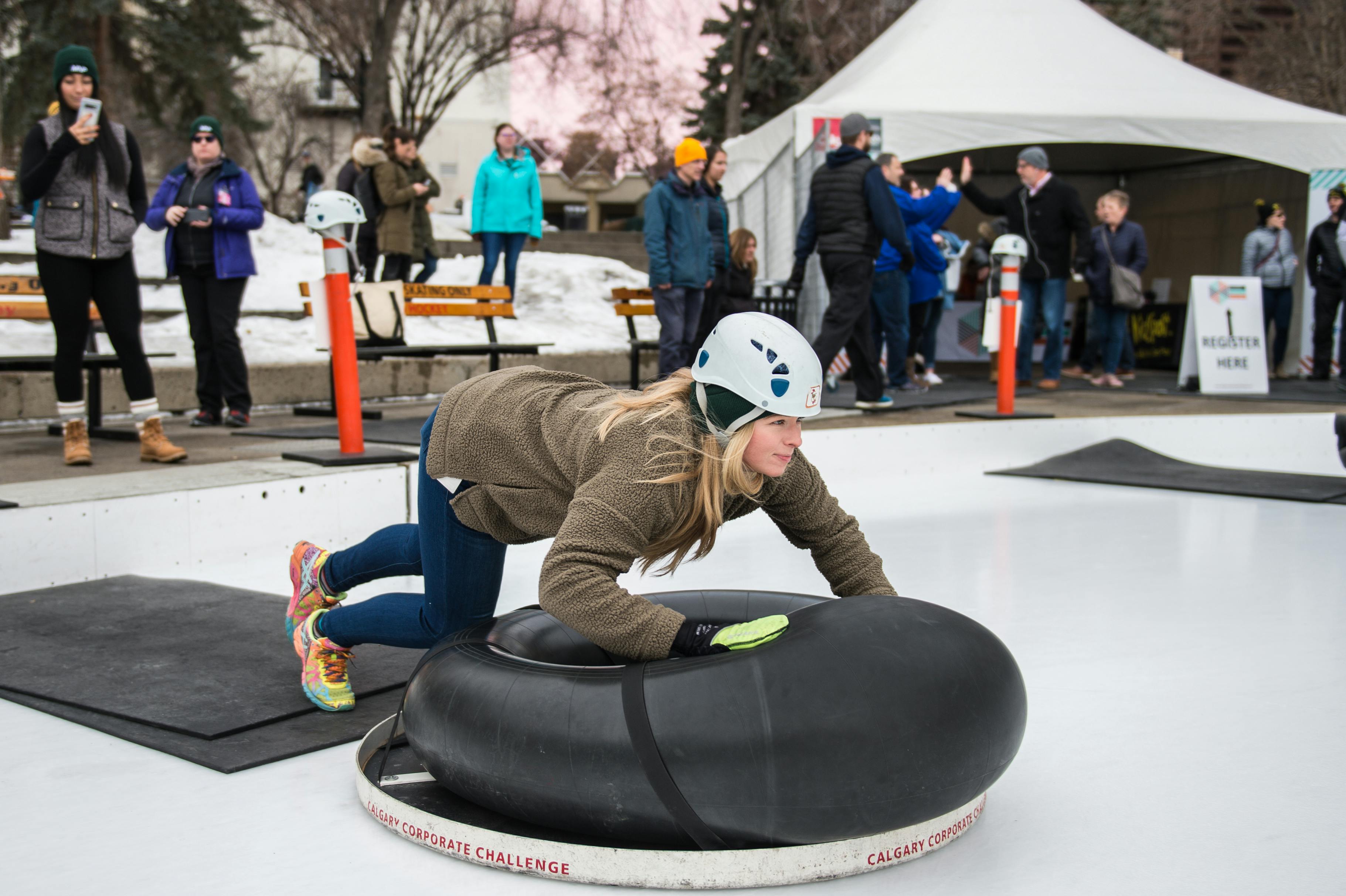 a woman in a helmet about to land on the ccc human bonspiel slider