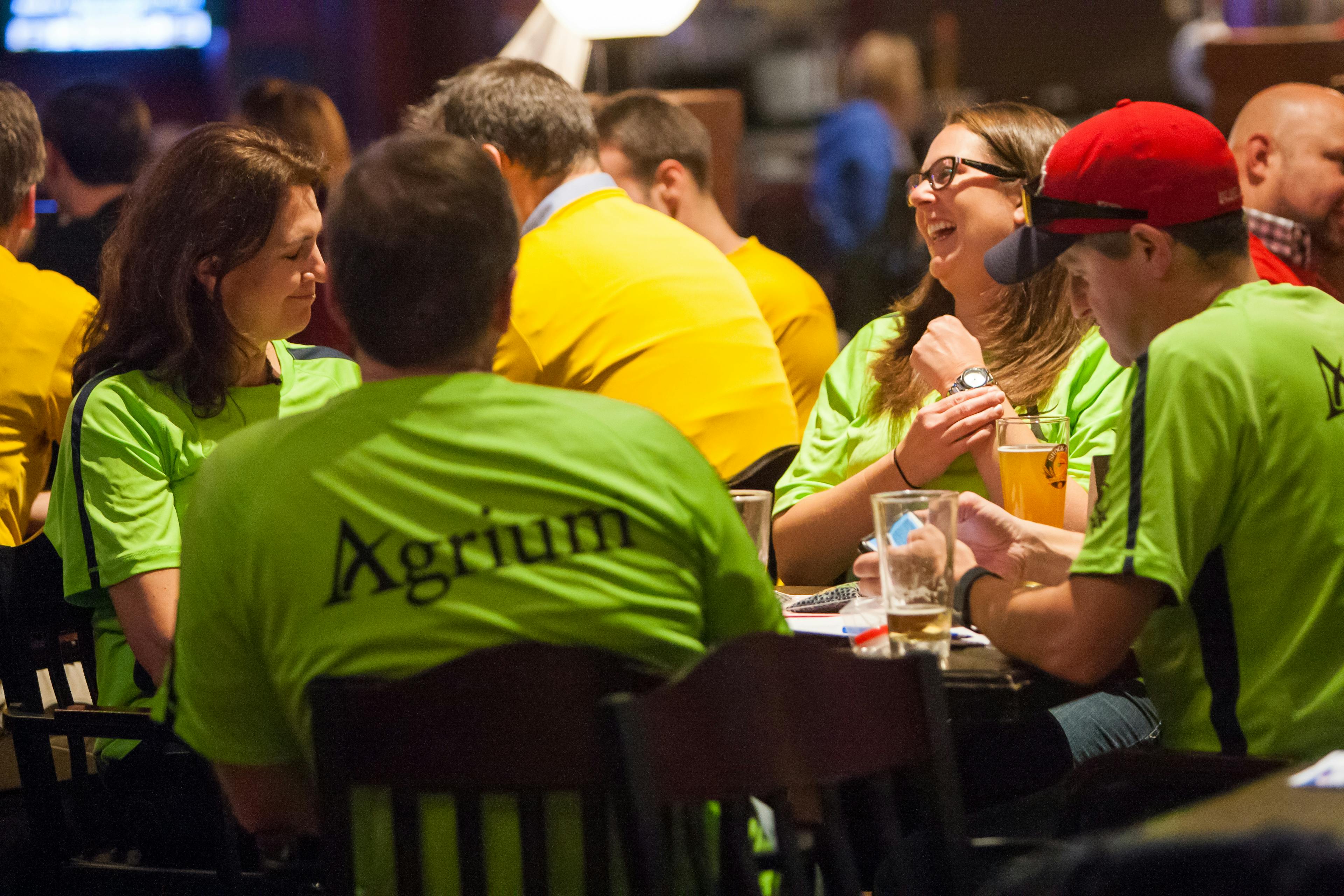 group of 4 people in green shirts playing trivia