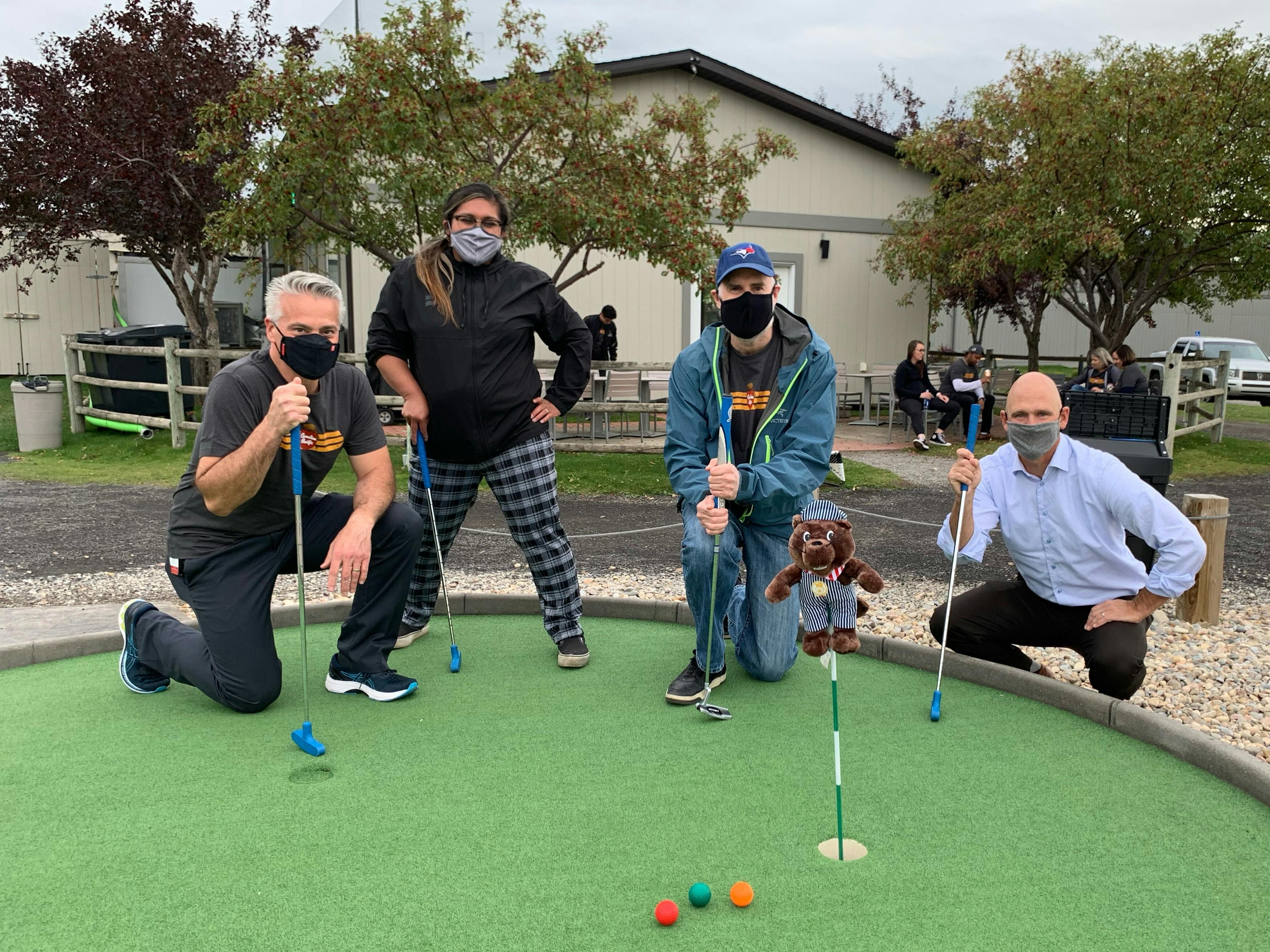 group of 4 masked people at mini golf