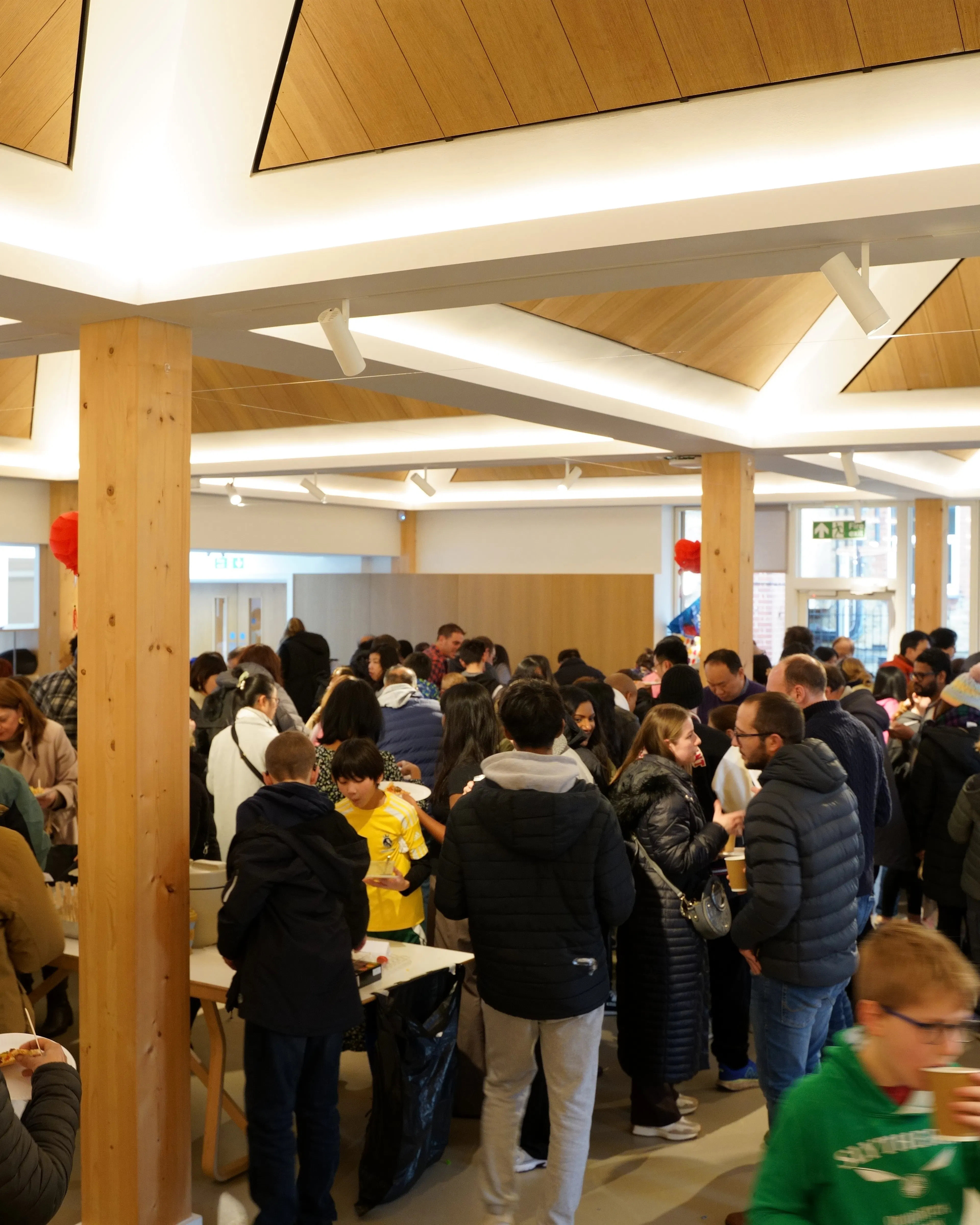 People chatting over refreshments in a bright church hall