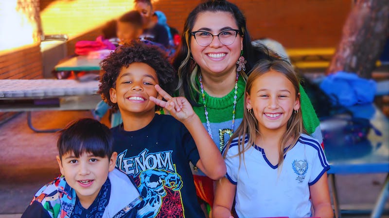 Alma Fuerte Charter School group photo with three students and one educator smiling. 