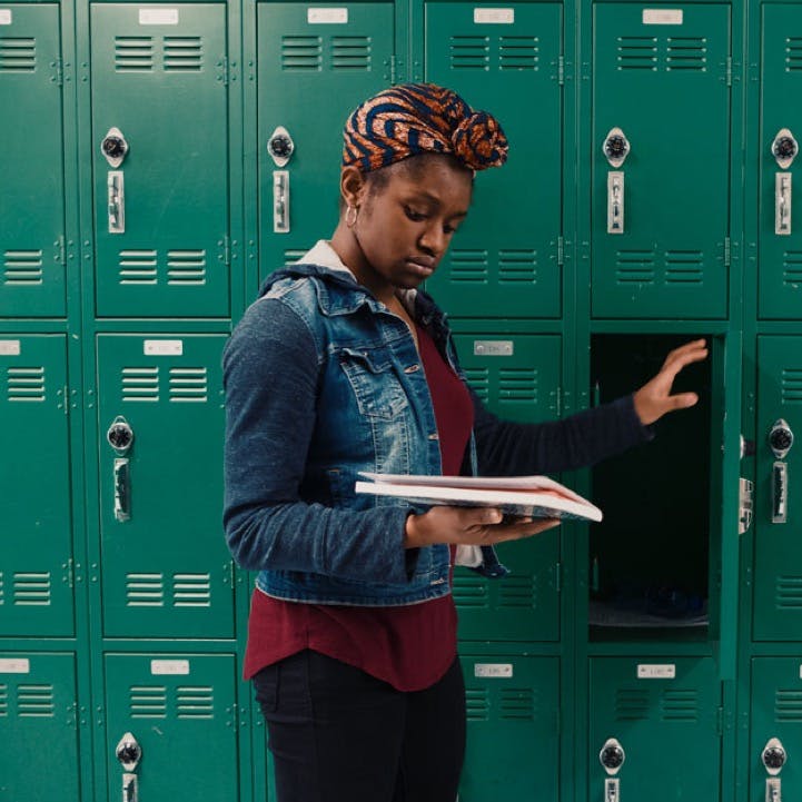 A girl at her locker holding a book