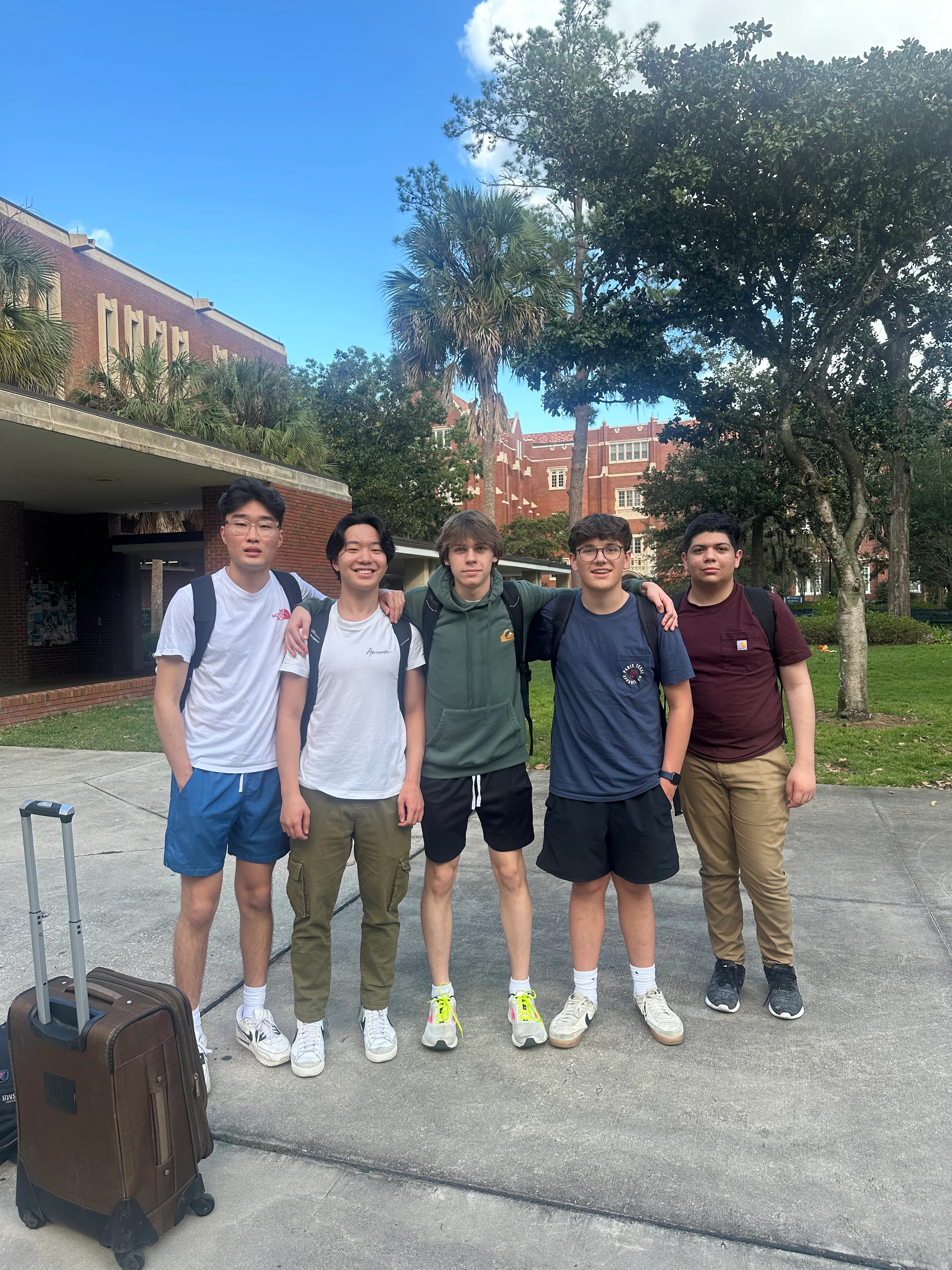 5 students pose for a photo outside