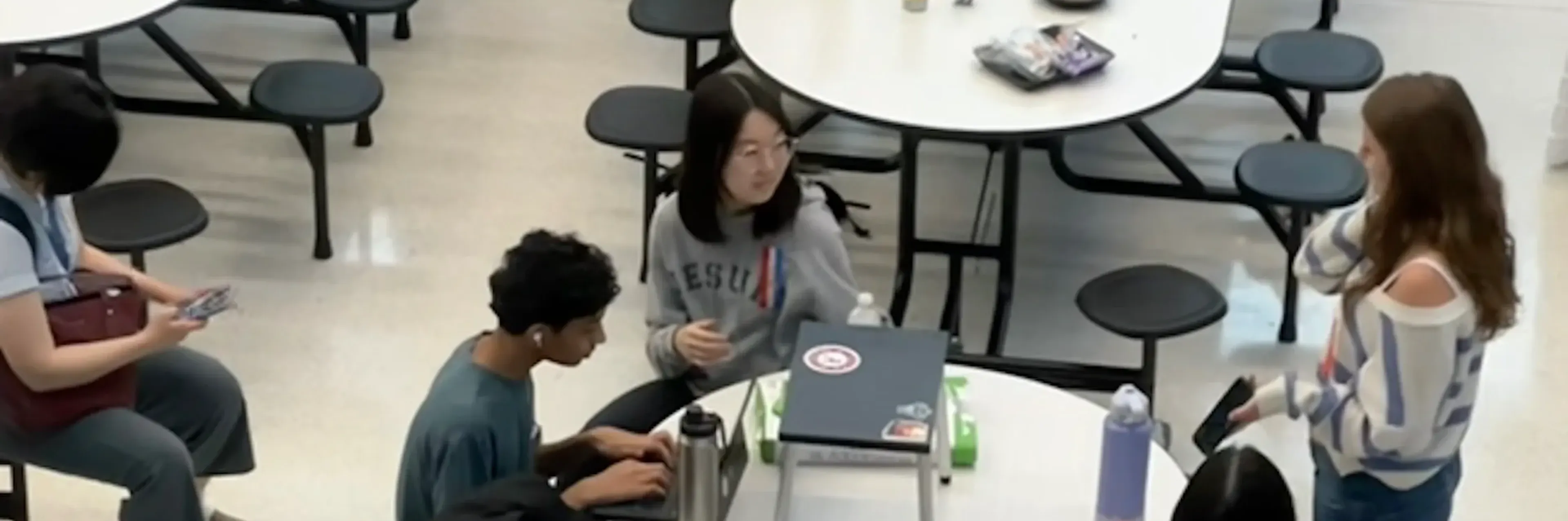 Students with laptops at a lunch table