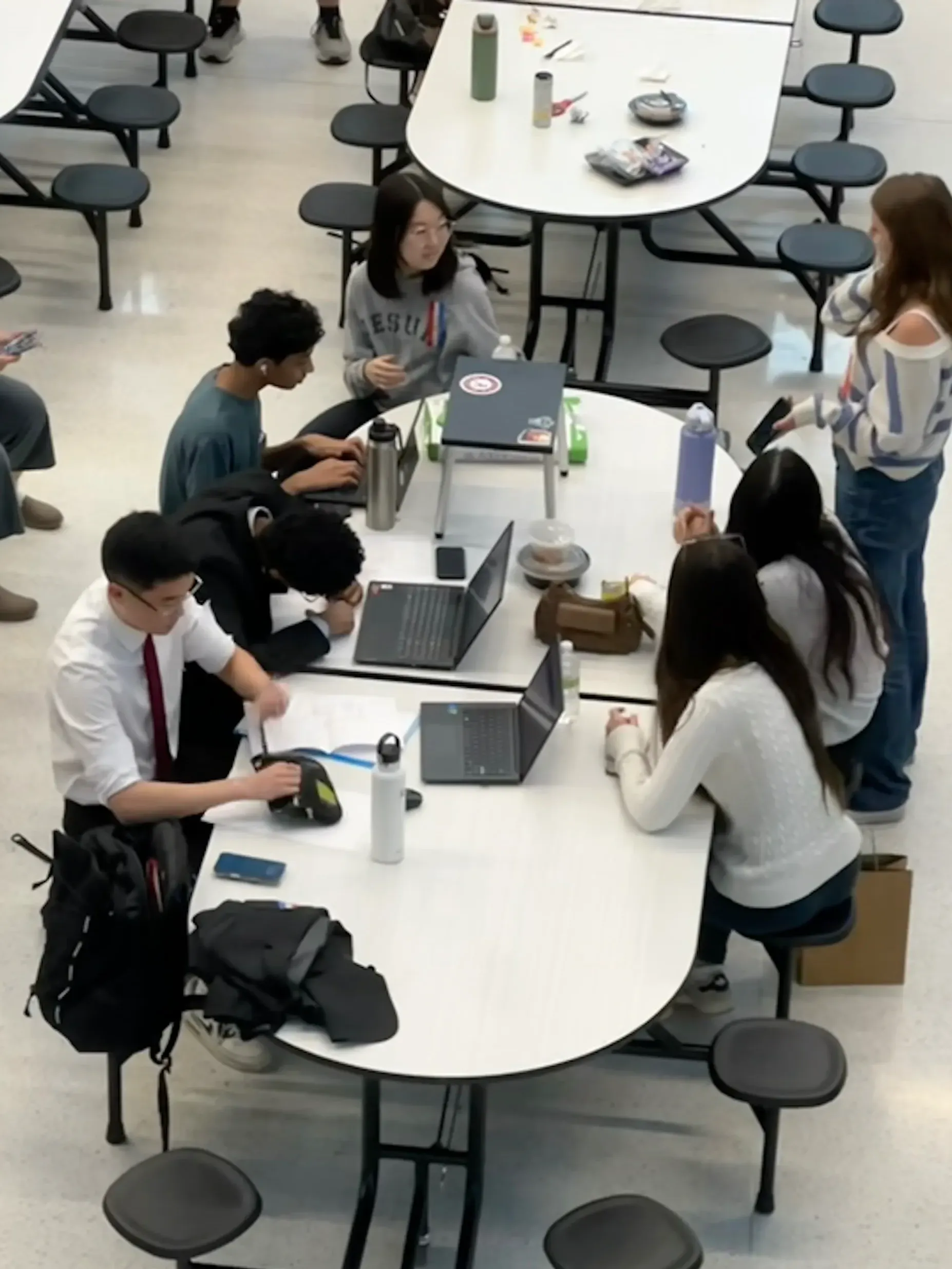 Students with laptops at a lunch table