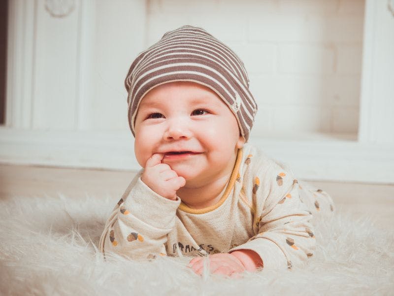 a cute baby baby posing on a carpet floor