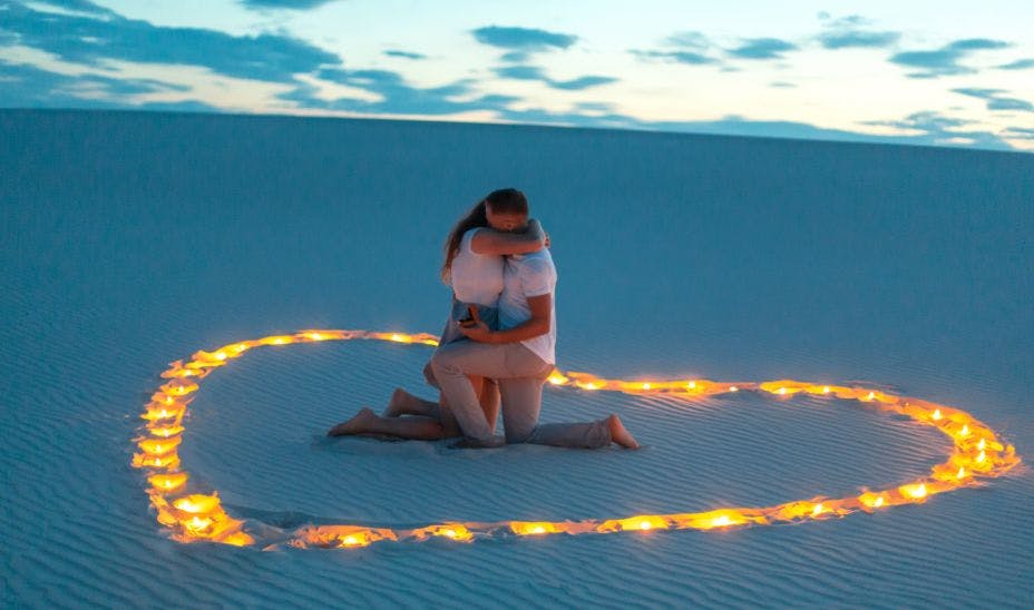 a couple hugging after proposal in desert