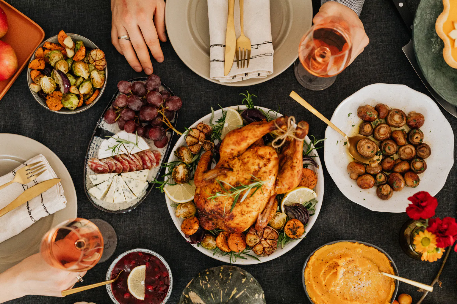 Thanksgiving dinner table with roasted turkey, sides, and festive dishes.