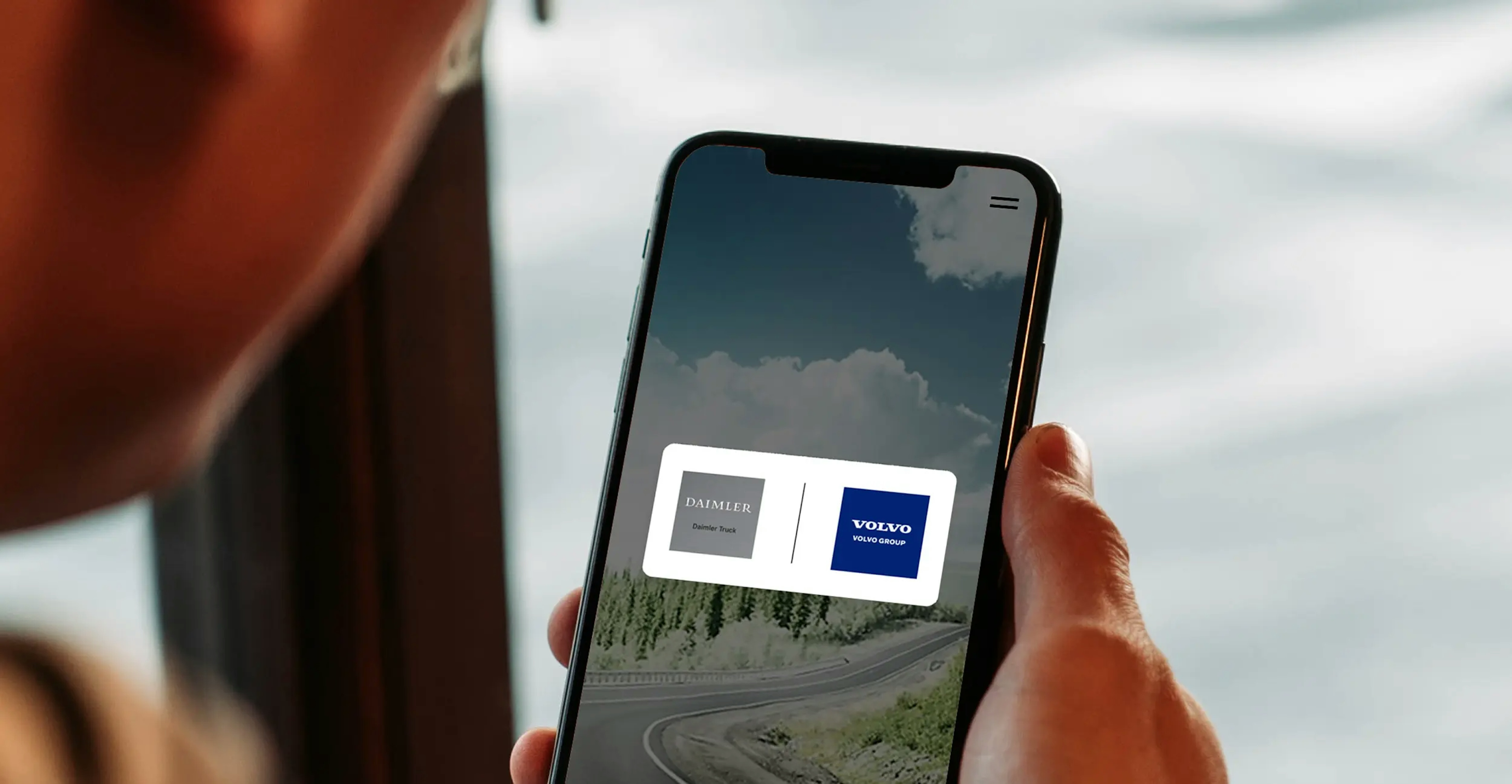 Bildschirm eines Handys, auf dem das Logo der Daimler Truck AG und der Volvo Group Brennstoffzellen-Joint Venture abgebildet ist.