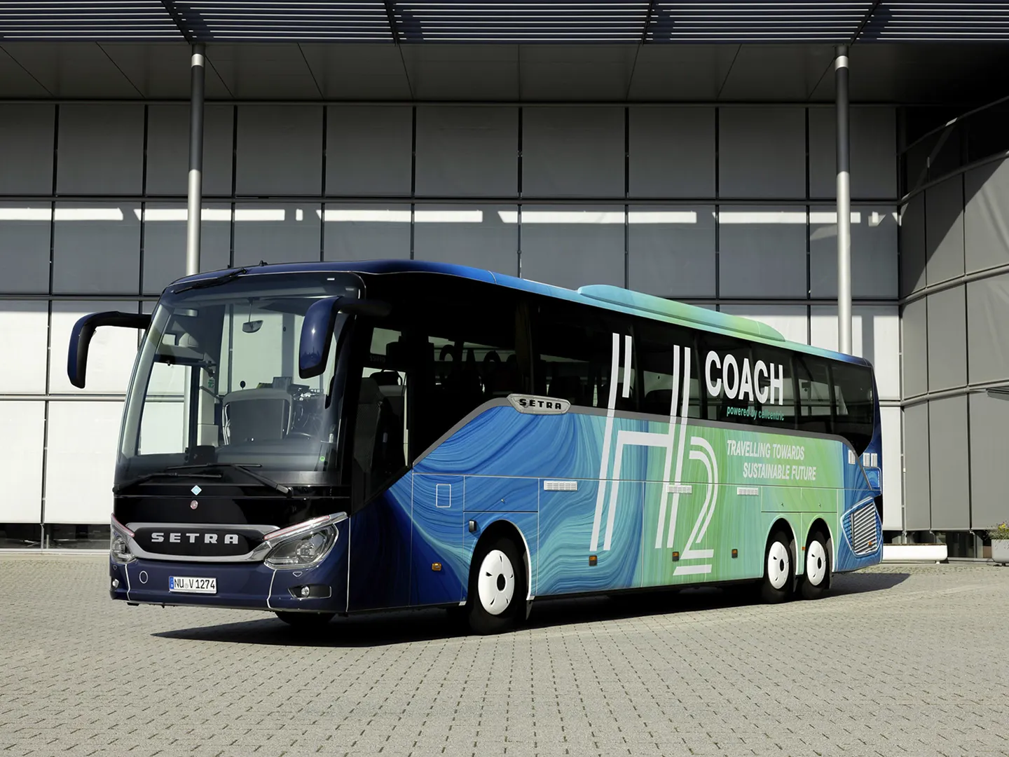 Setra-Reisebus mit „cellcentric“-Branding für Wasserstoff-Brennstoffzellen vor einem modernen Gebäude