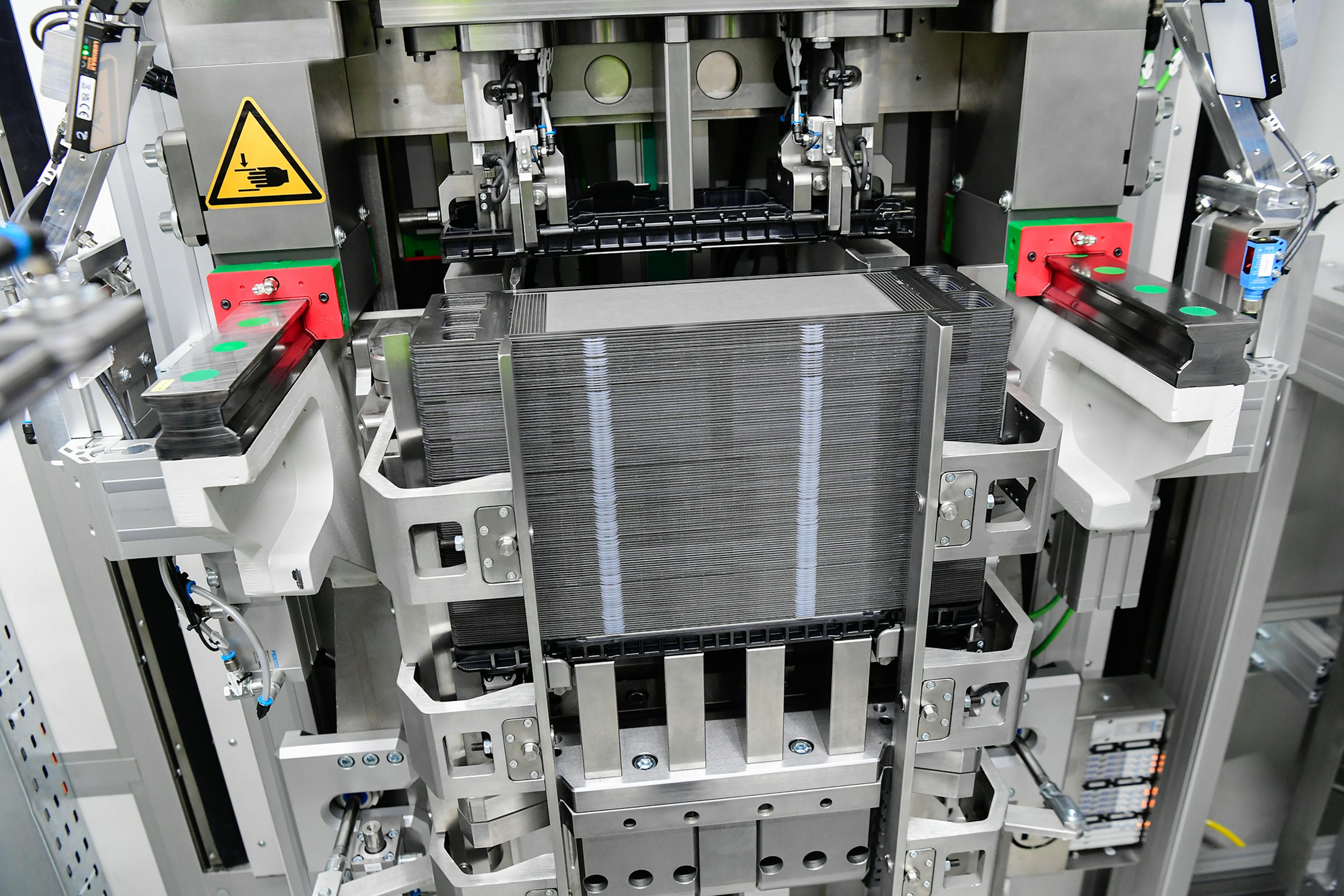 Fuel cell stack in precise holder within an automated production system.
