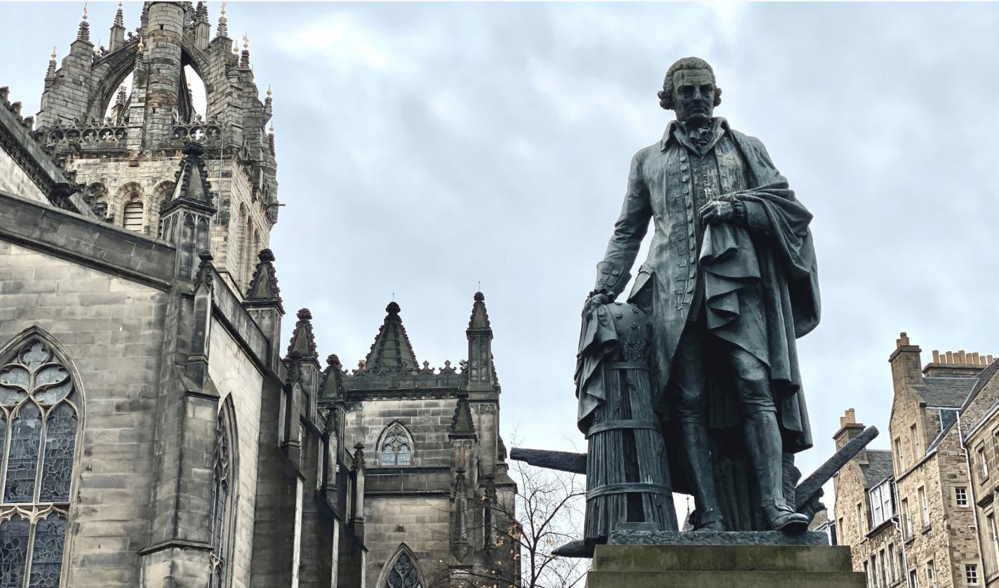 Photo by Matt May of Adam Smith statue on Edinburgh's Royal Mile, standing beside something that resembles a dalek