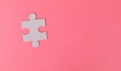 Puzzle piece on pink background