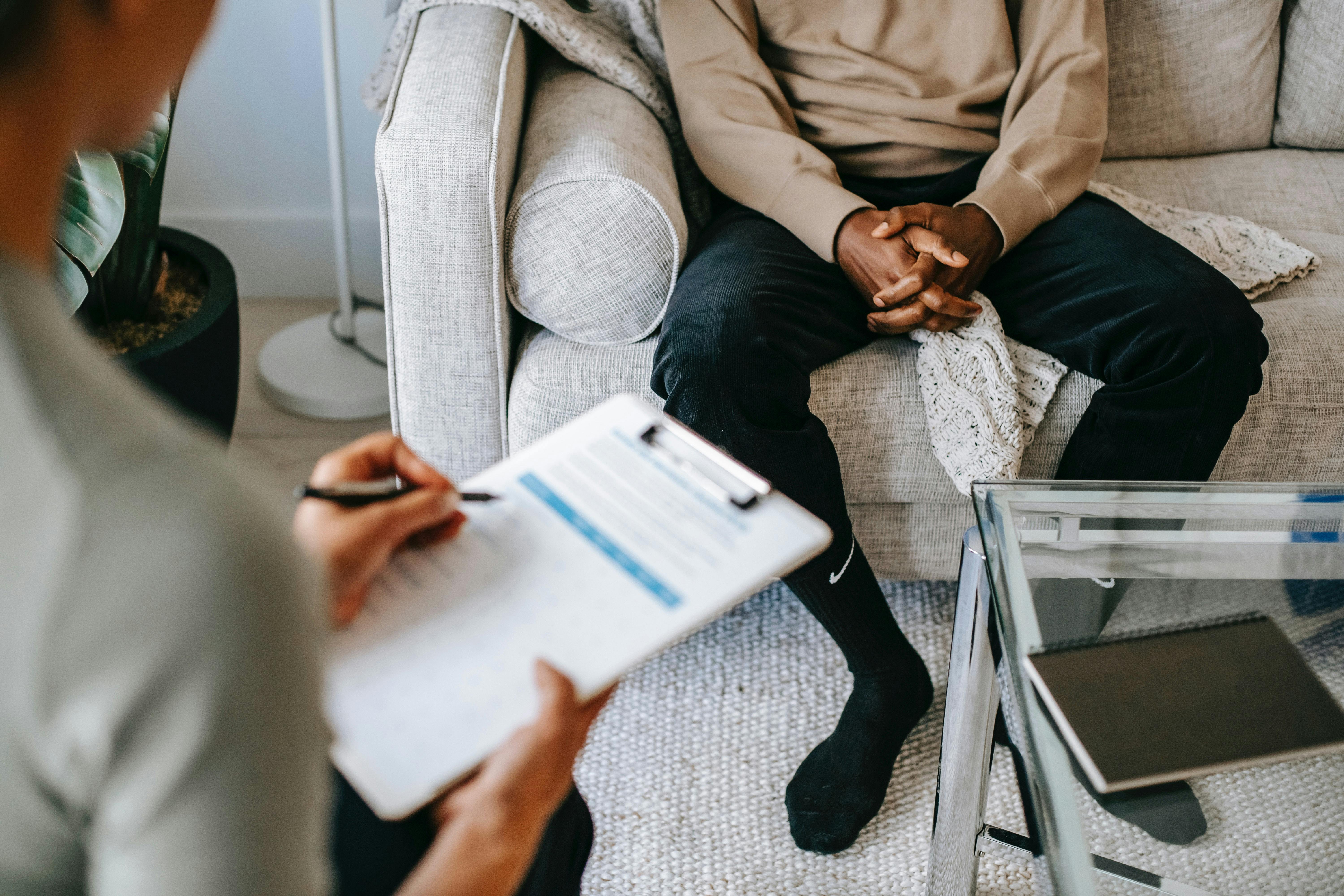 man sitting on couch talking to therapist