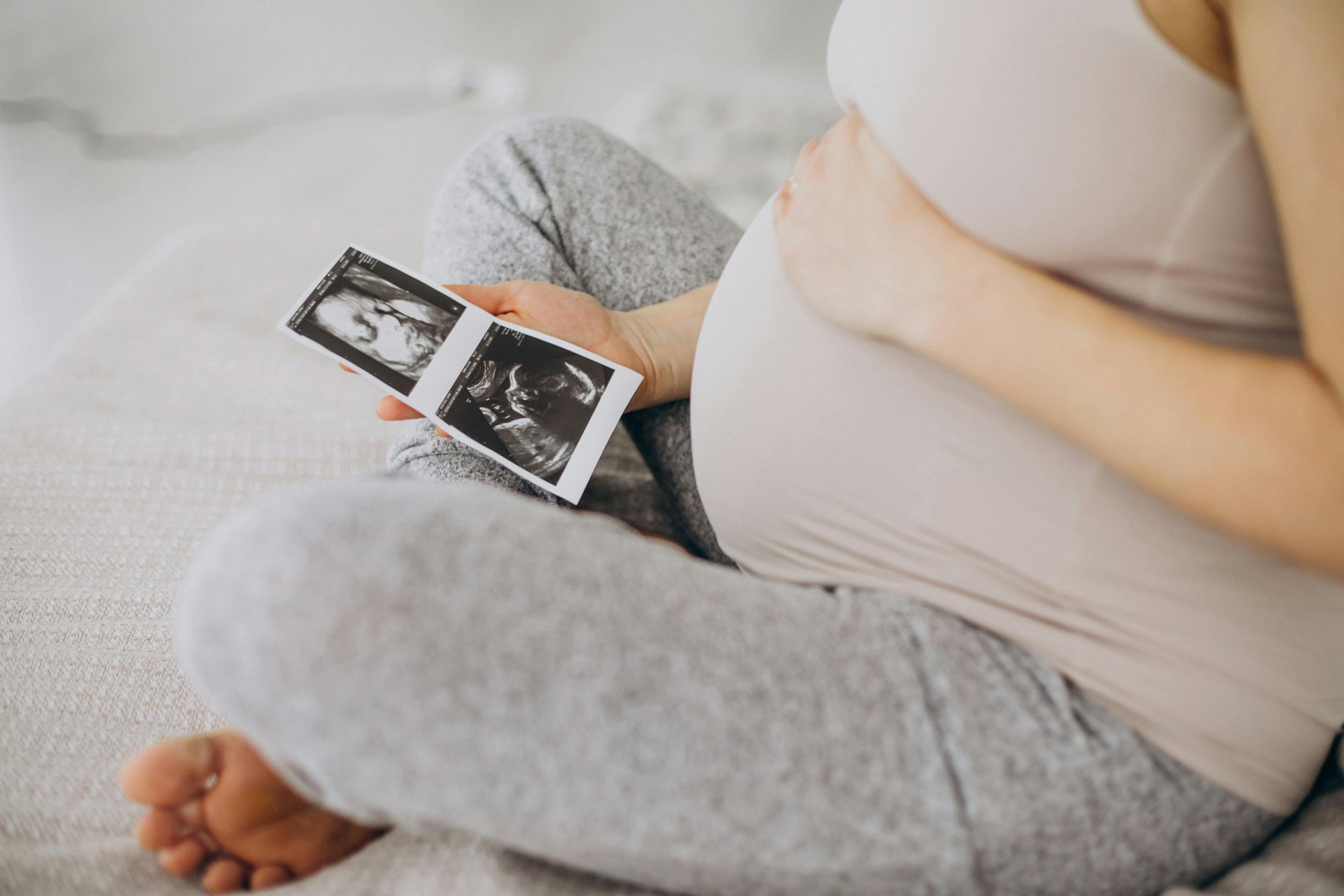 White pregnant woman looks at ultrasound