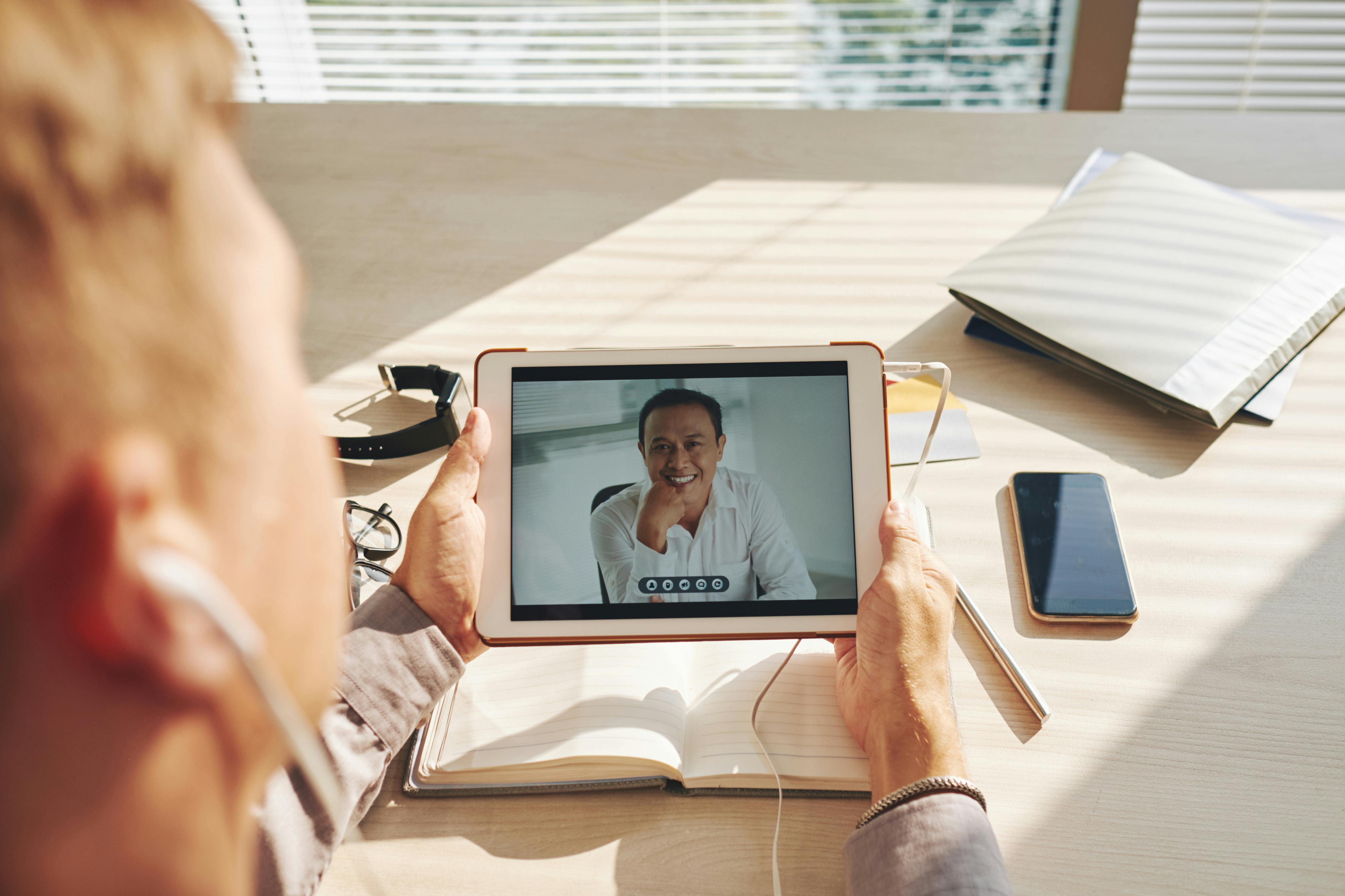 A male patient speaks with a male mental health professional in an online session