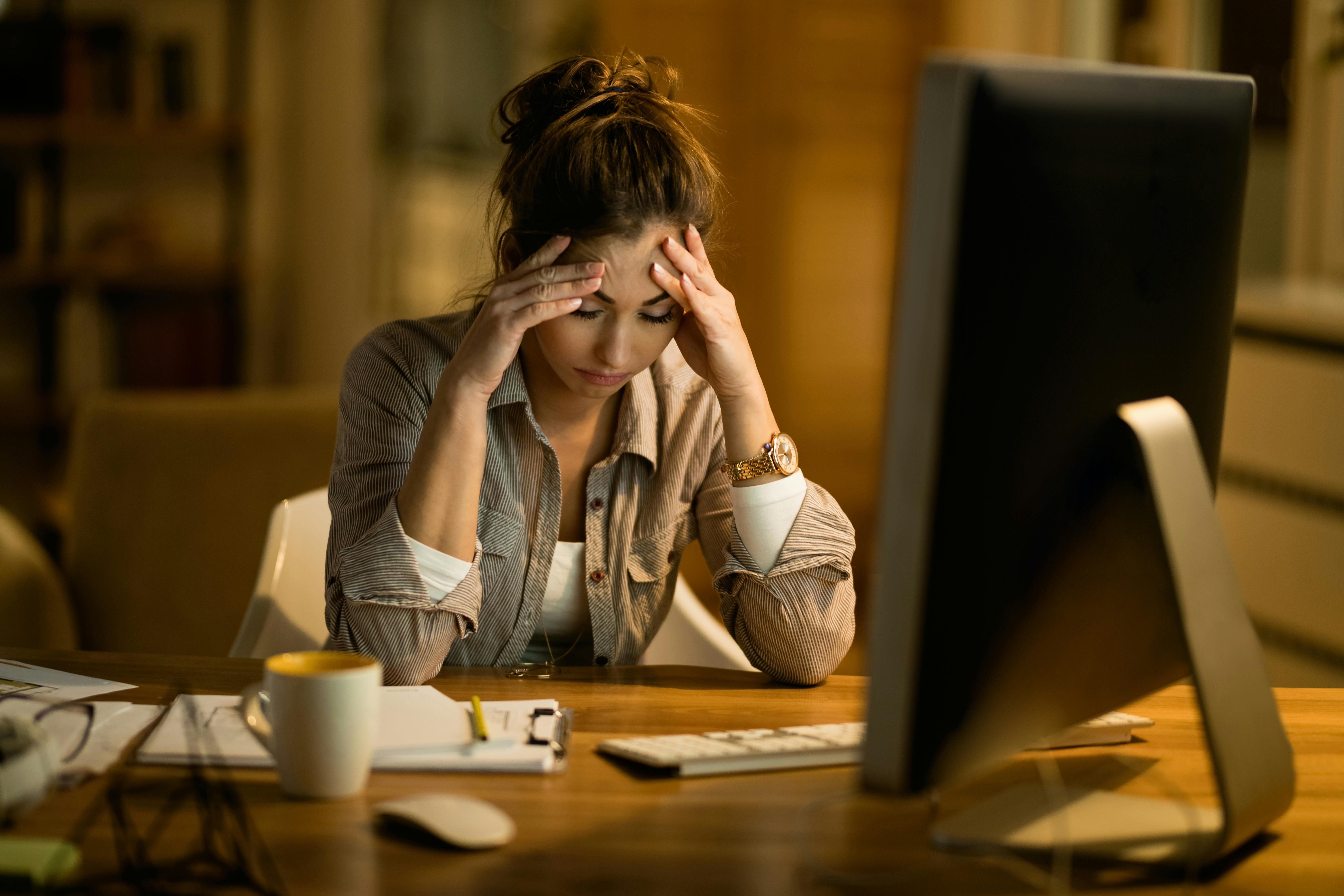 Young white female at desk, can’t concentrate and is tired