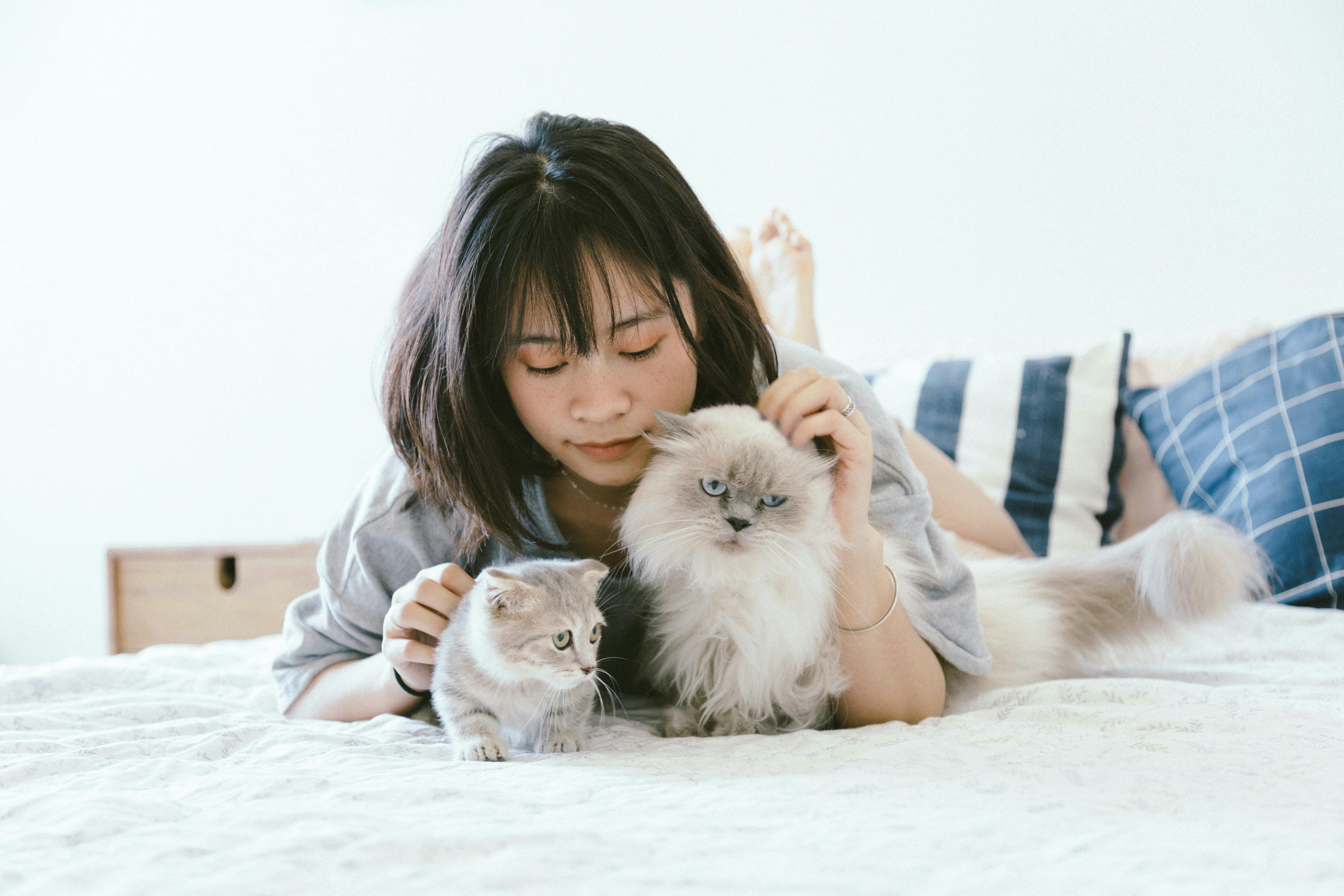 woman petting two cats