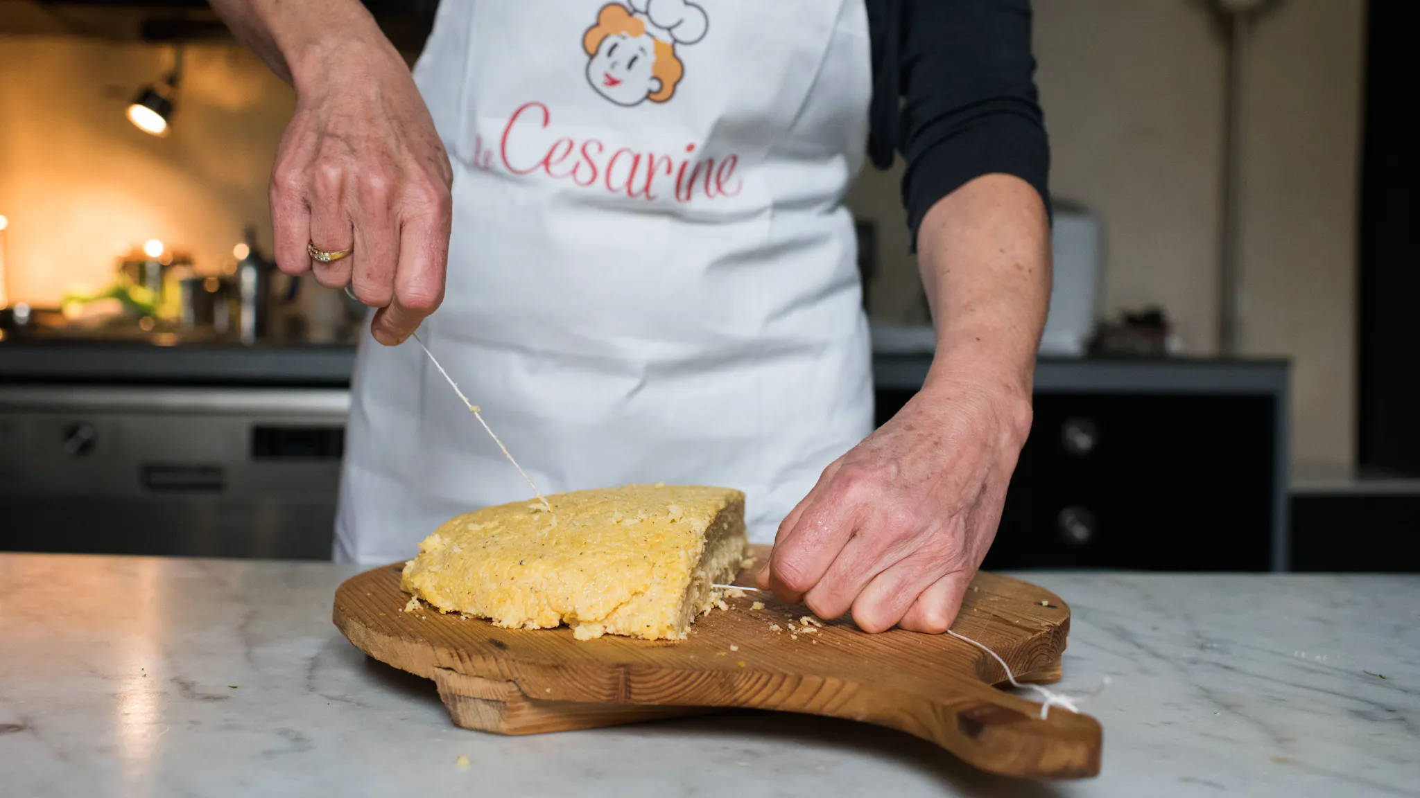 Cesarina coupe la polenta sur une planche à découper