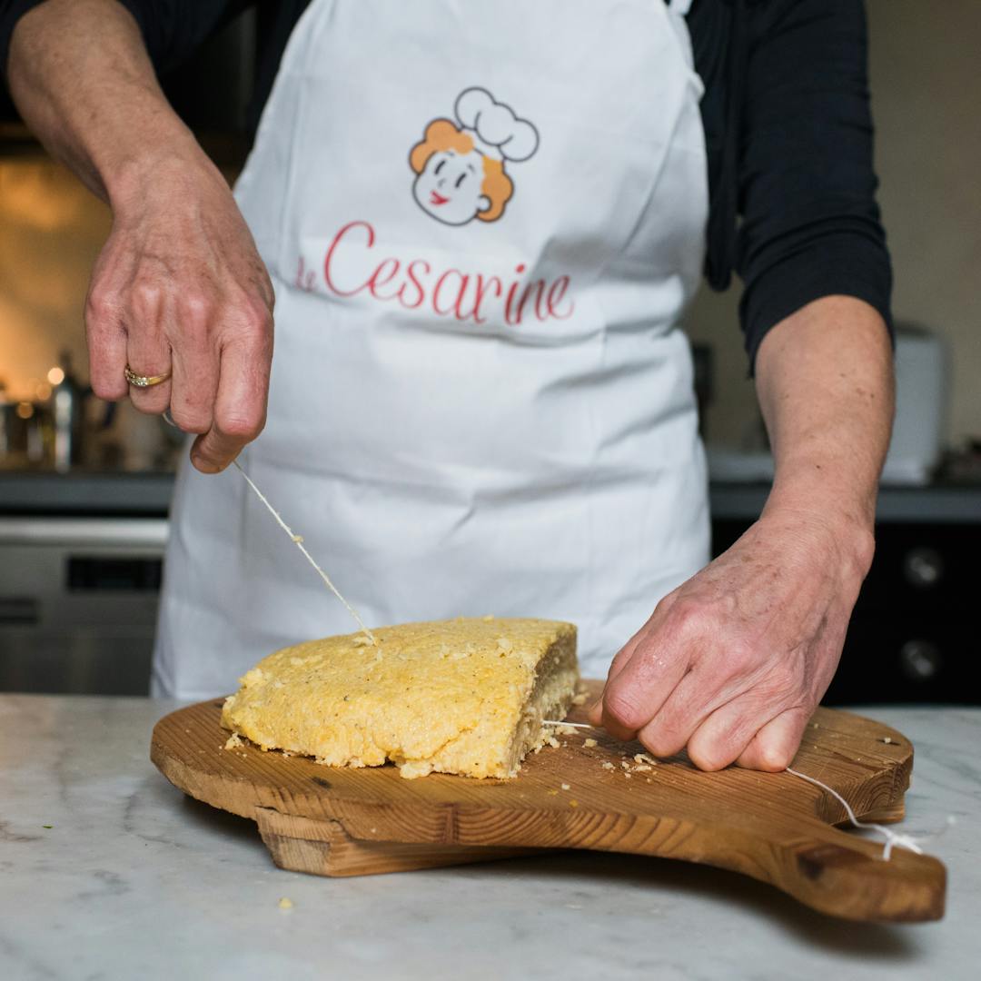 Cesarina cutting polenta on a wood board