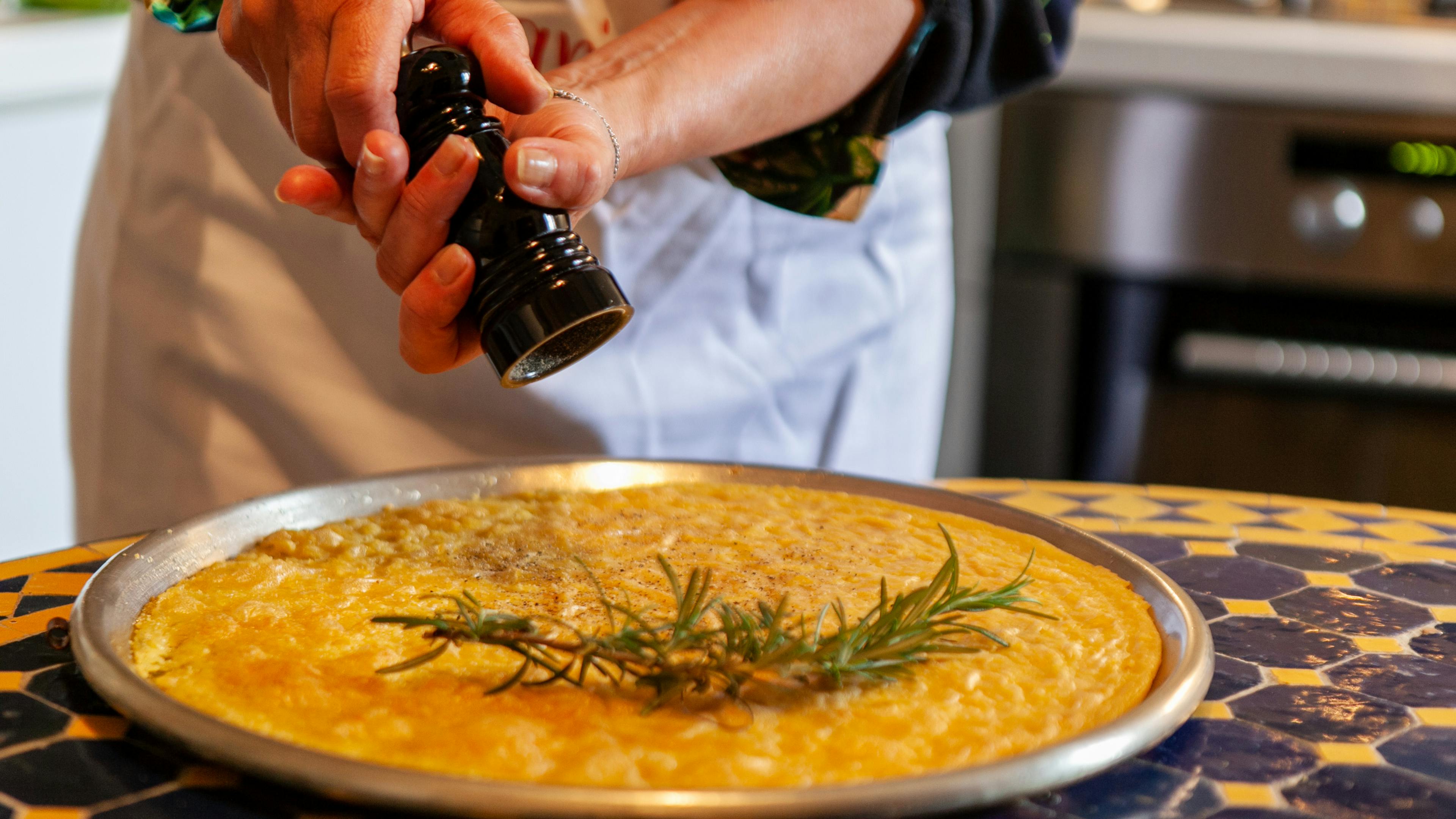 Cesarina grinds pepper onto a chickpea flatbread