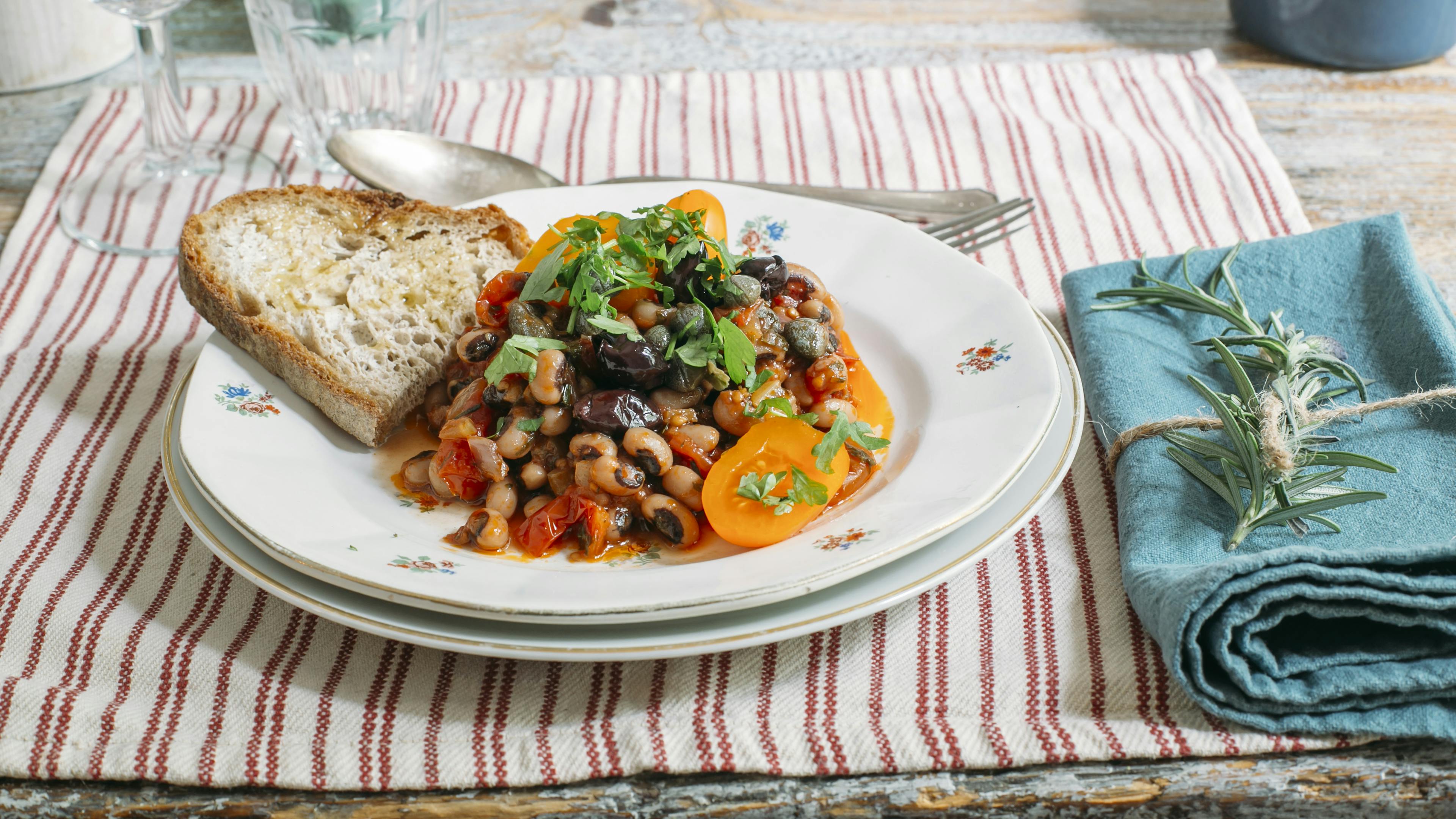 Dish with bean stew accompanied by toasted bread crostini