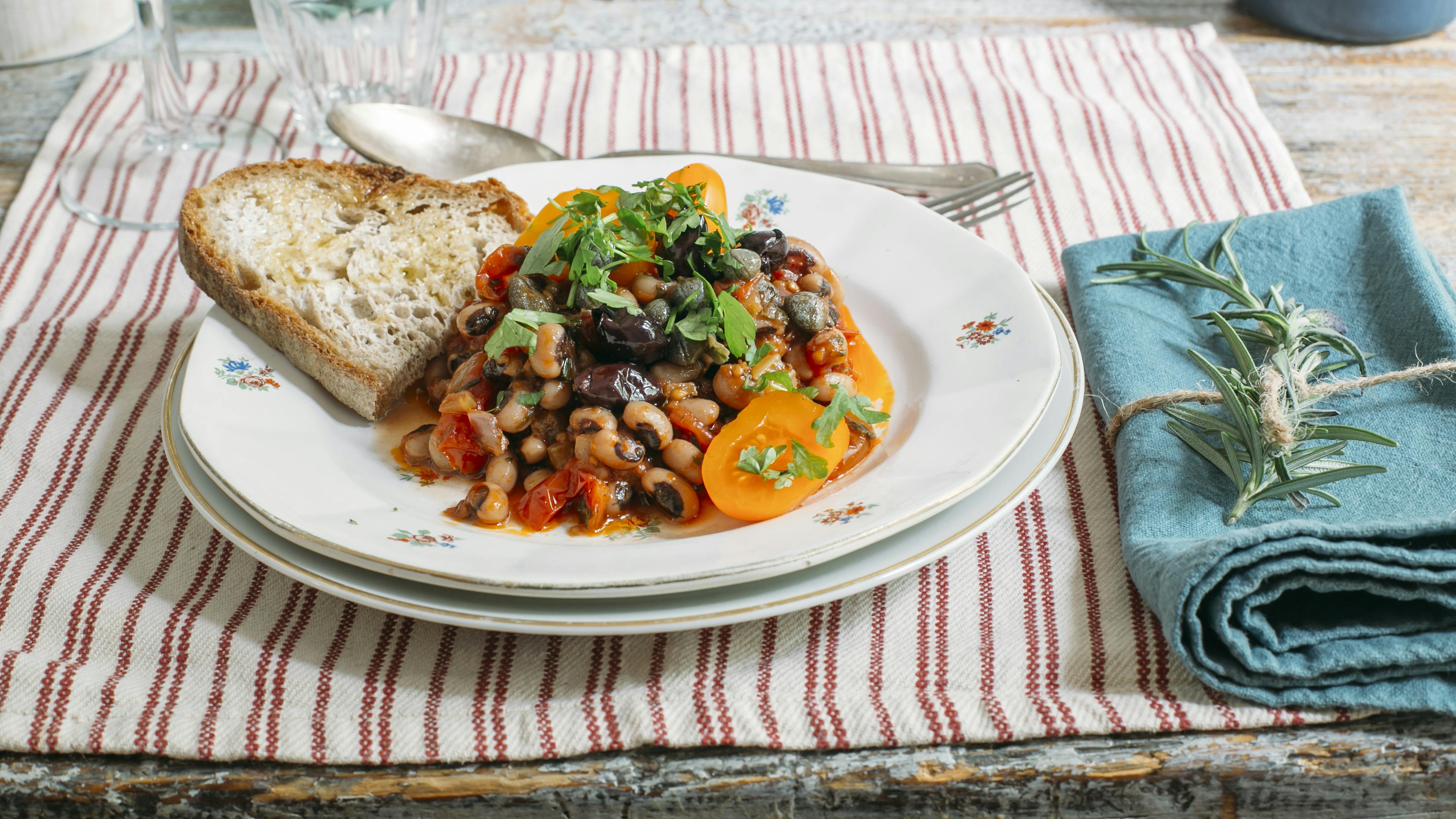 Piatto con stufato di fagioli dall'occhio accompagnati da crostone di pane tostato