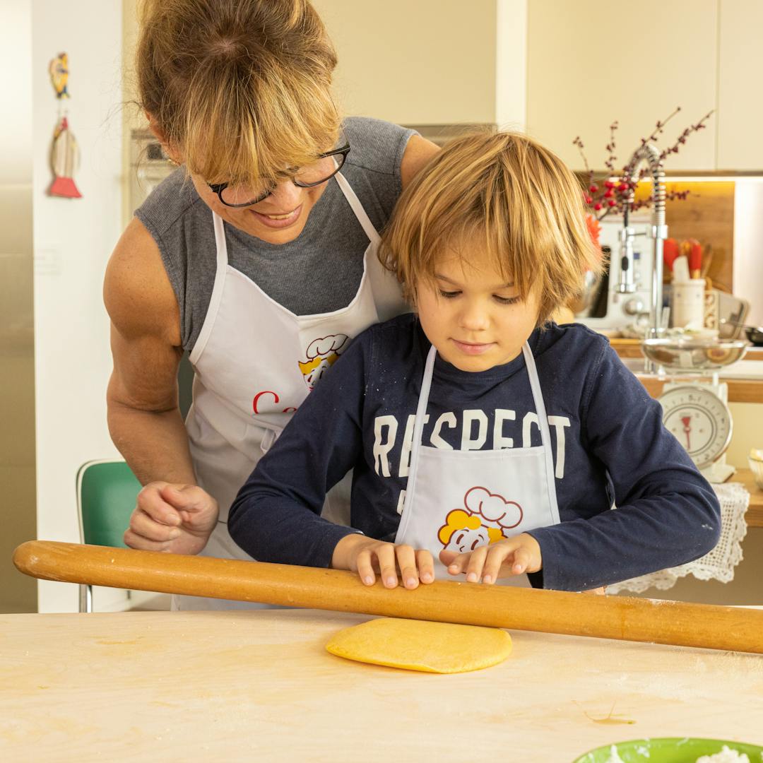 Cesarina and children using rolling pin in a cooking class in Bologna