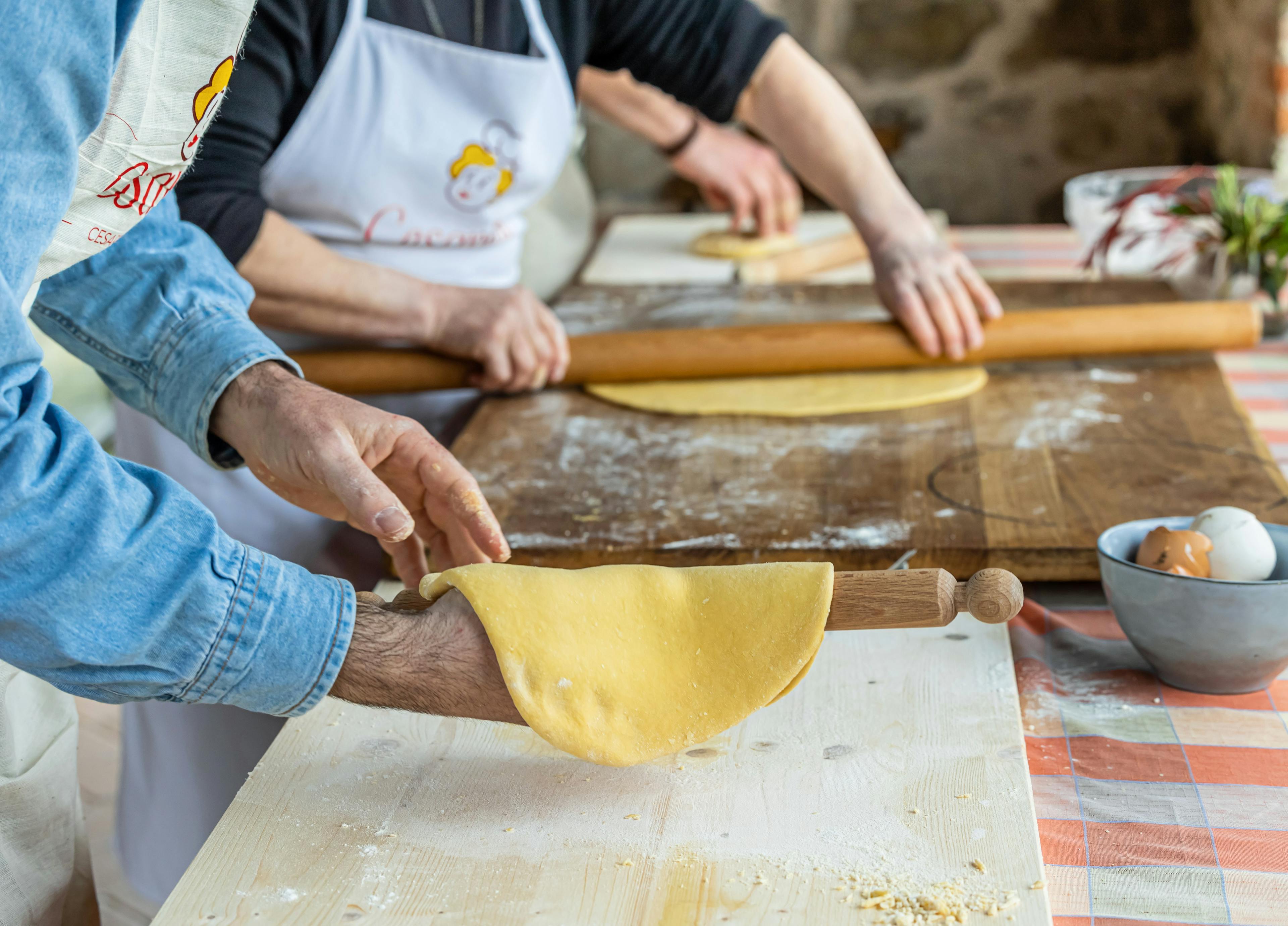 People using rolling pin in a pasta cooking class
