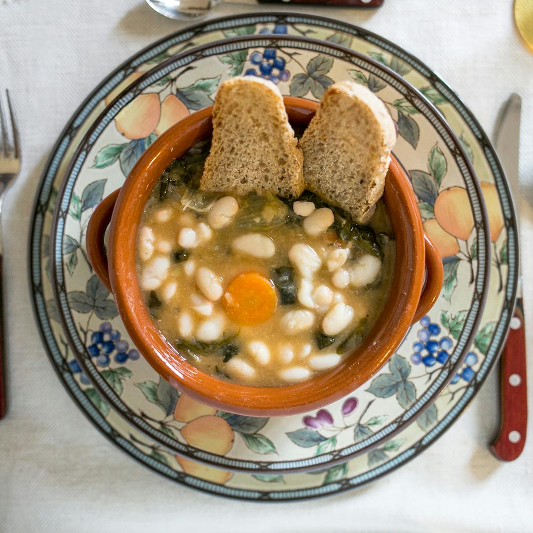 Vista dall'alto di un piatto di ribollita toscana con due crostini di pane