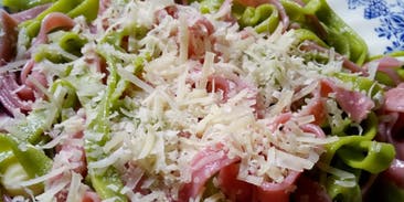 piatto con tagliatelle verdi e rosse con ricotta salata