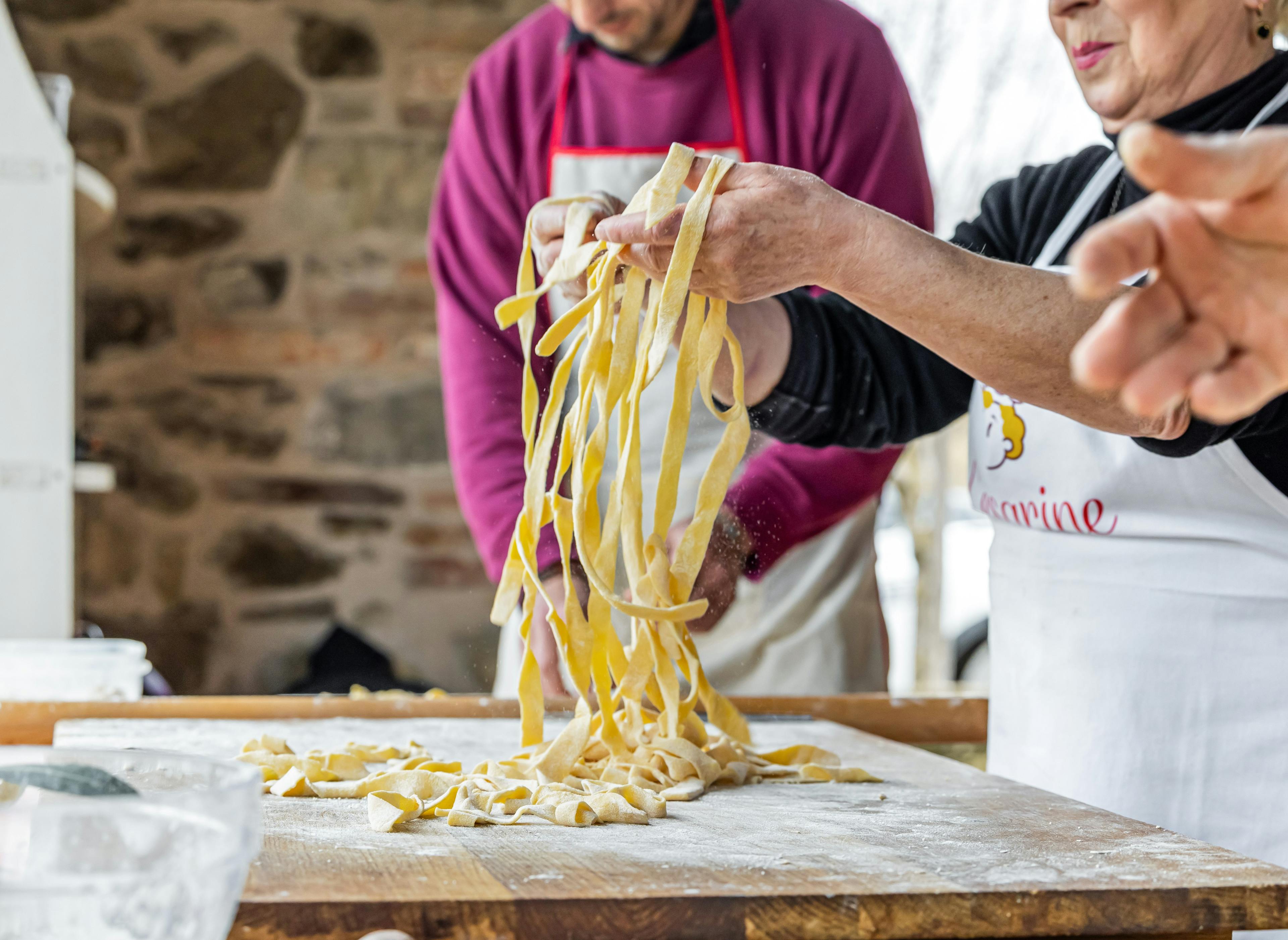persone che stanno preparando le tagliatelle fatte in case