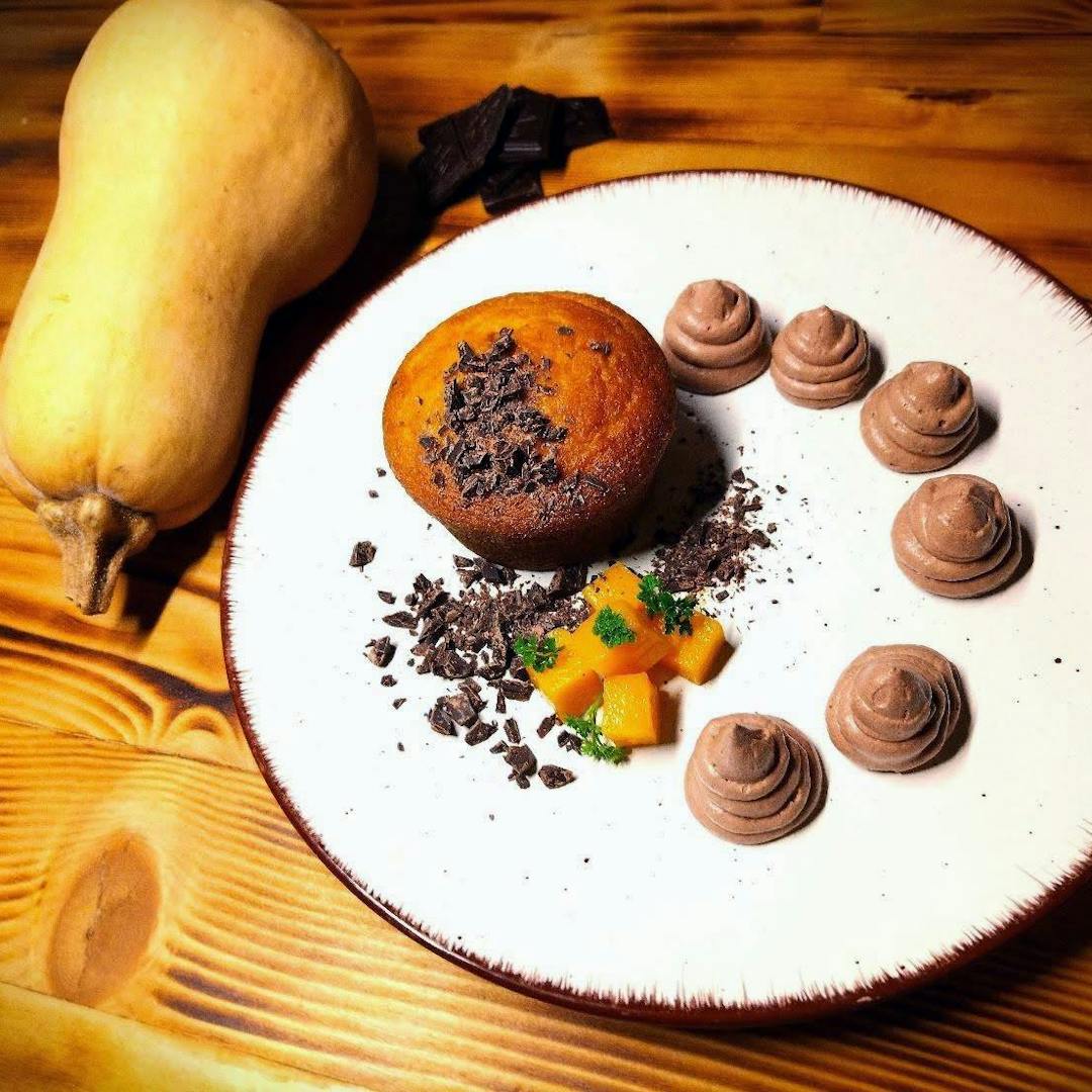 Tortino di zucca e cioccolato su piatto con decorazioni