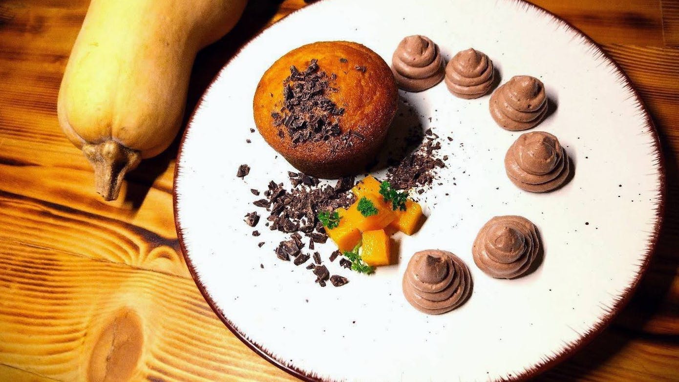 Tortino di zucca e cioccolato su piatto con decorazioni