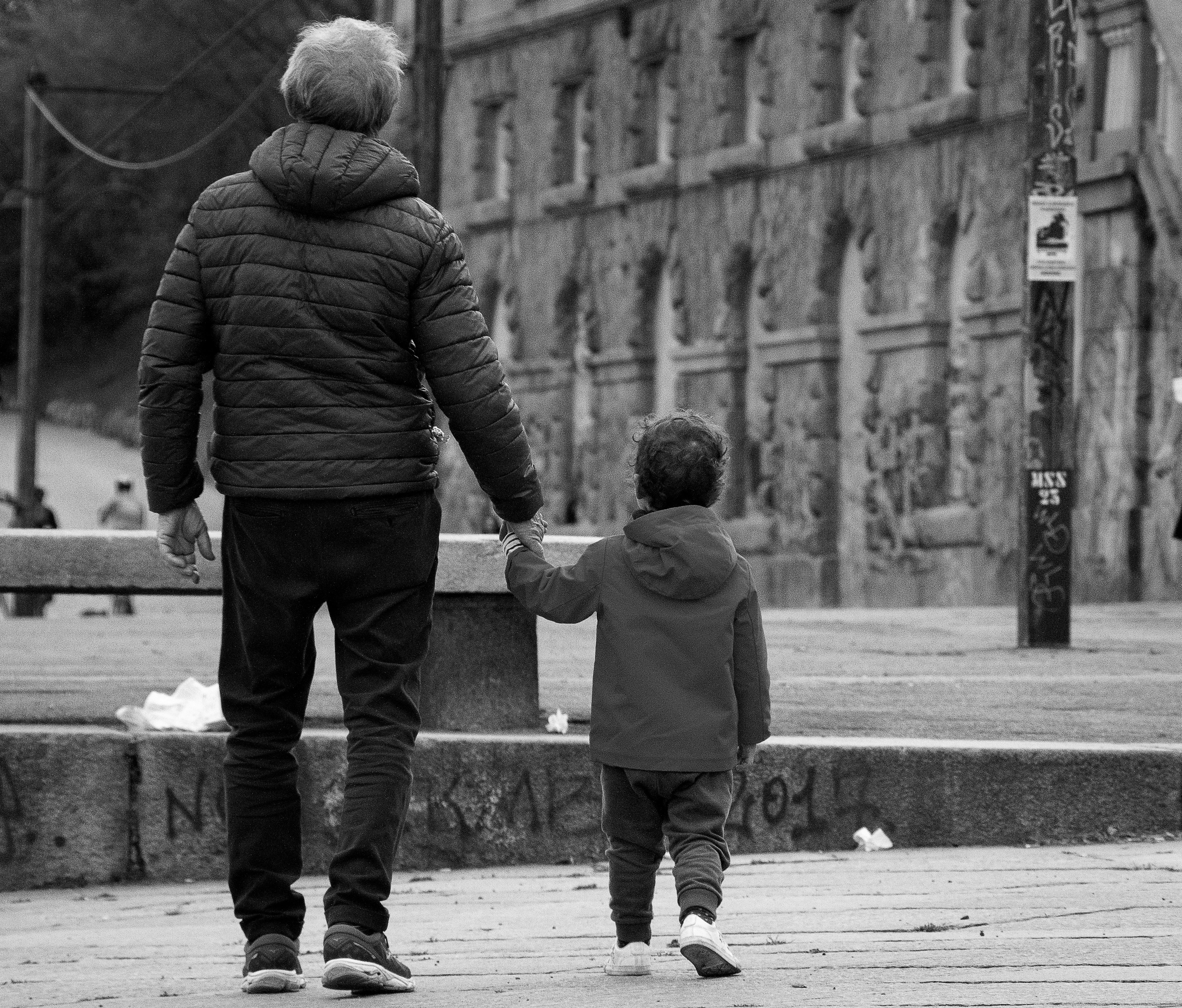 Nonno e nipote che girano per strada tenendosi per mano