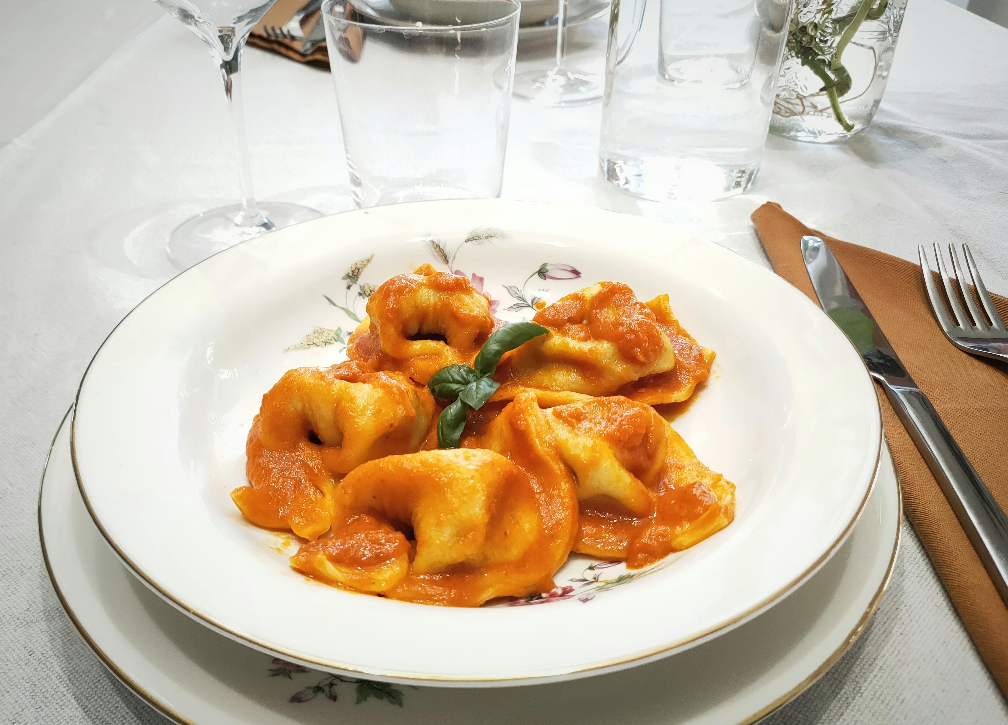 Piatto con Tortelli alla zucca conditi con sugo al pomodoro