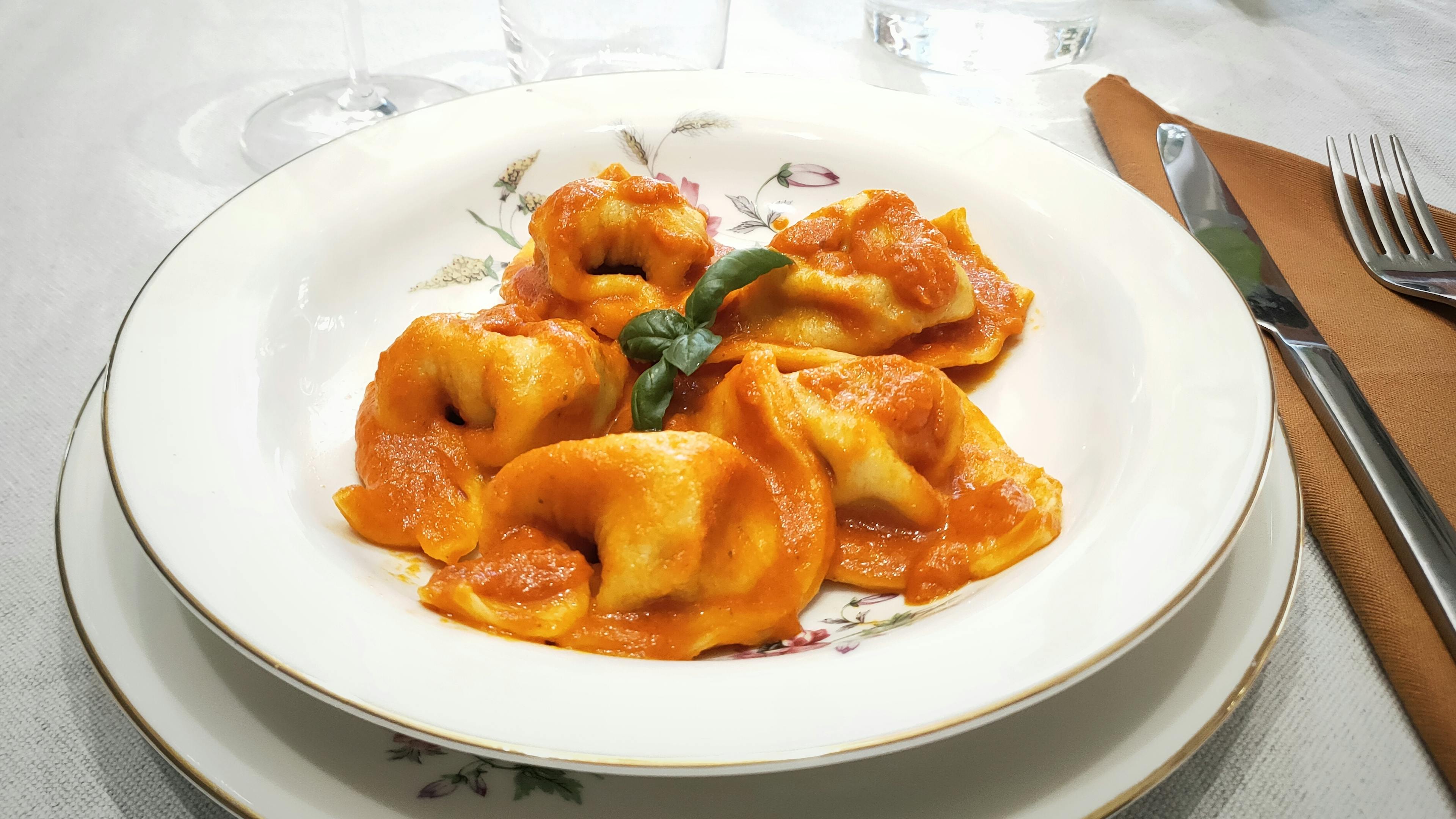 Dish of pumpkin tortelli topped with tomato sauce