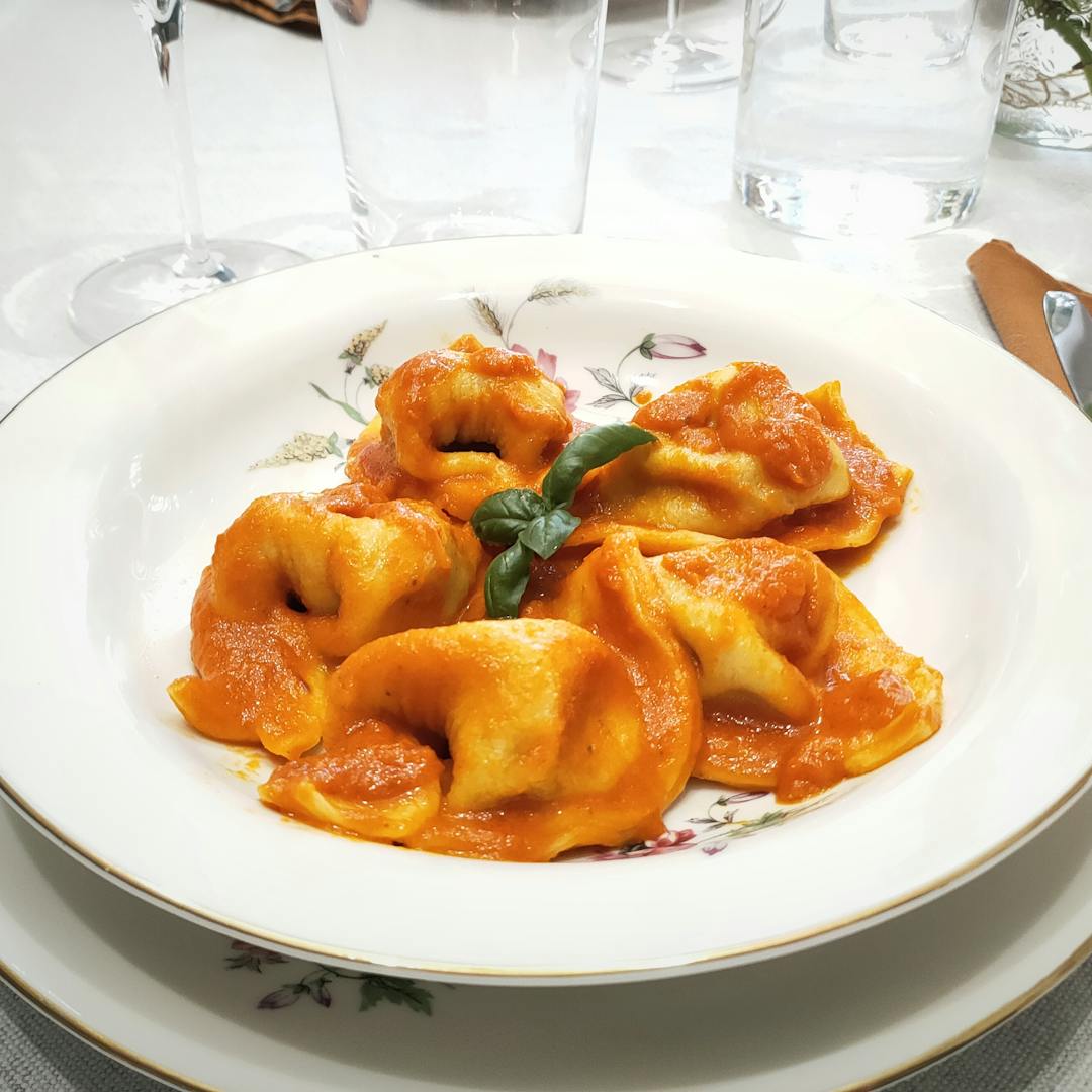 Plate of pumpkin tortelli topped with tomato sauce