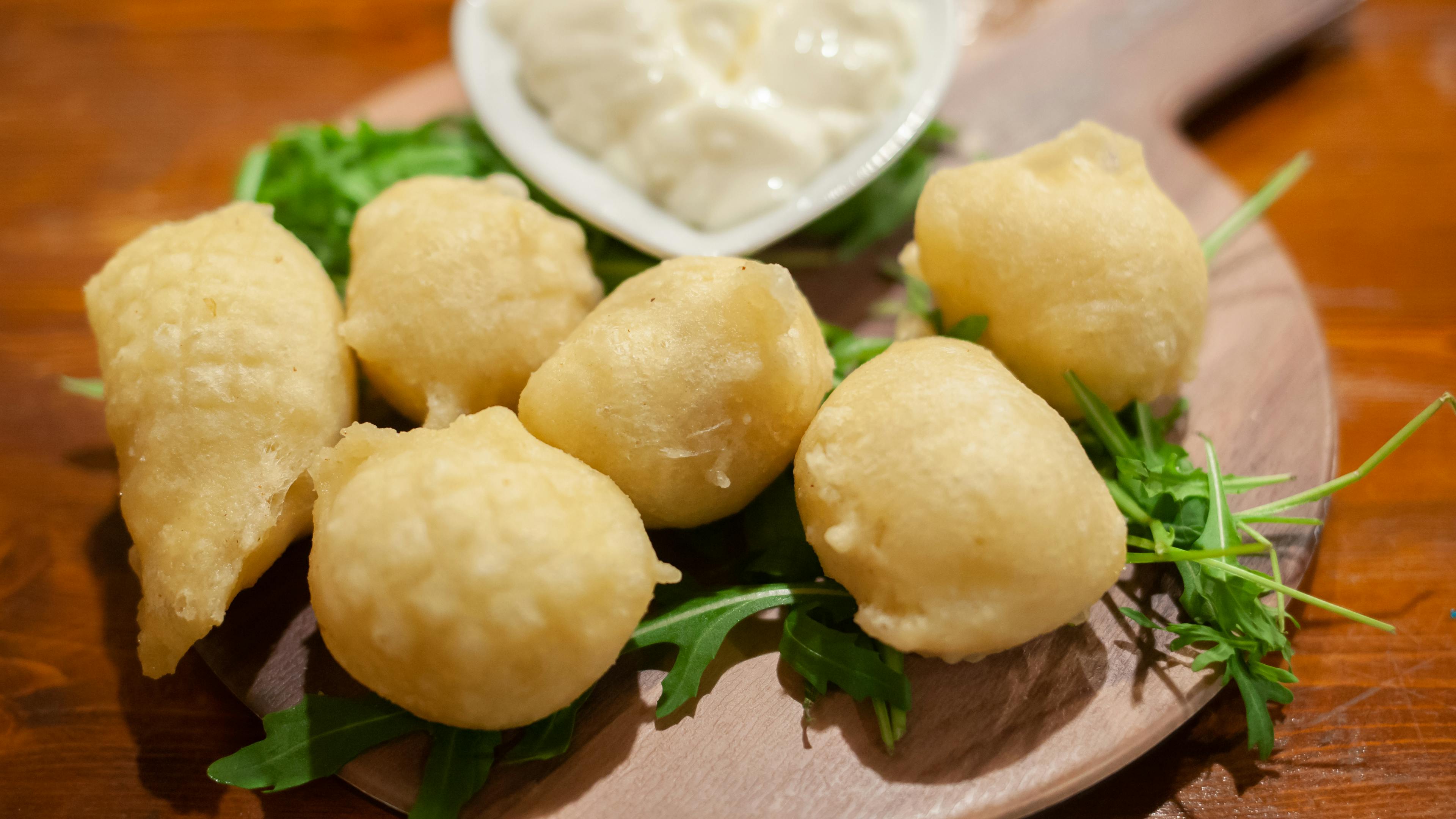 Florentine coccoli on a wooden board with stracchino cheese