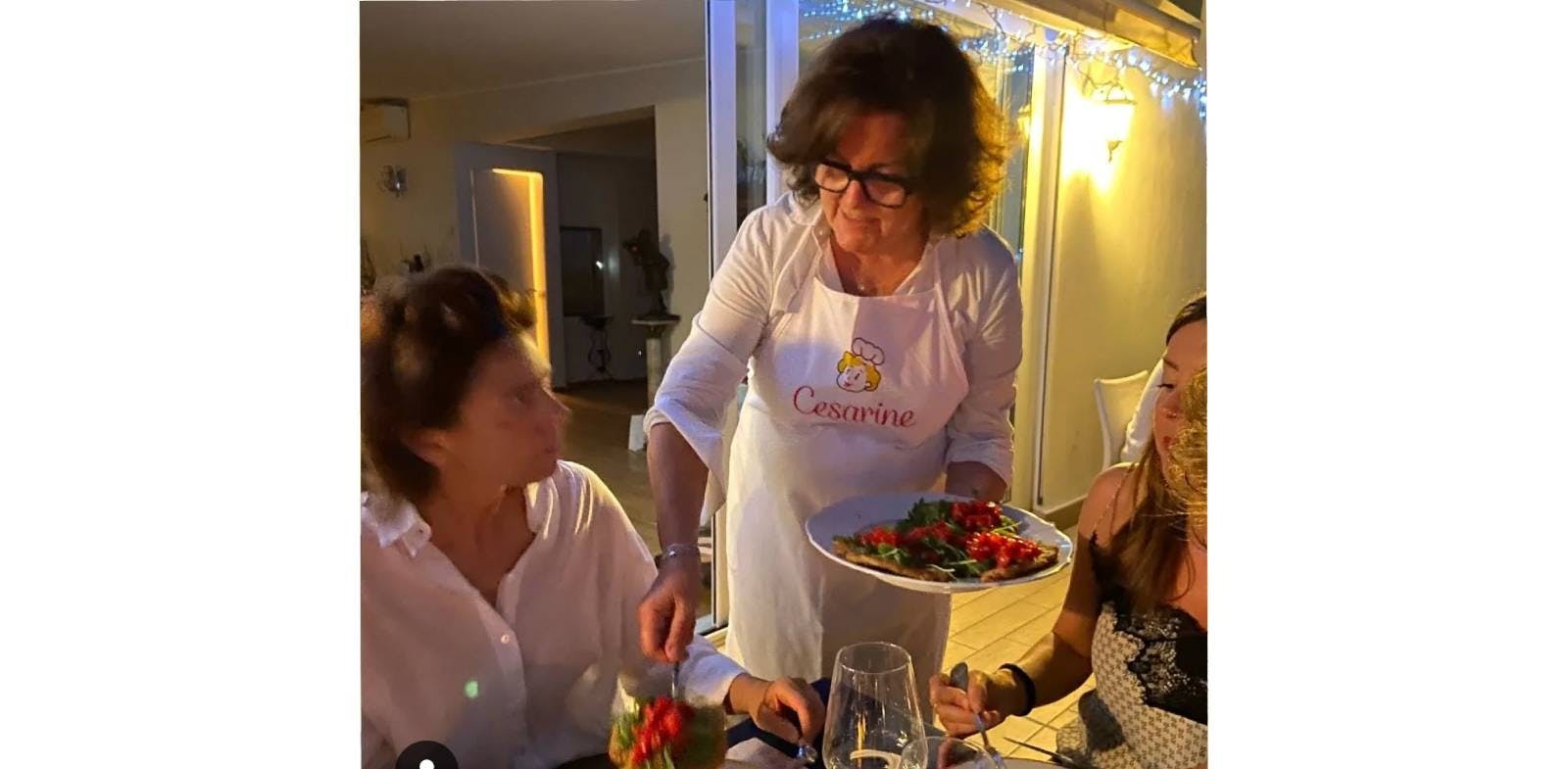 Cesarina Sissi da Milano mentre serve la cotoletta milanese a una sua ospite