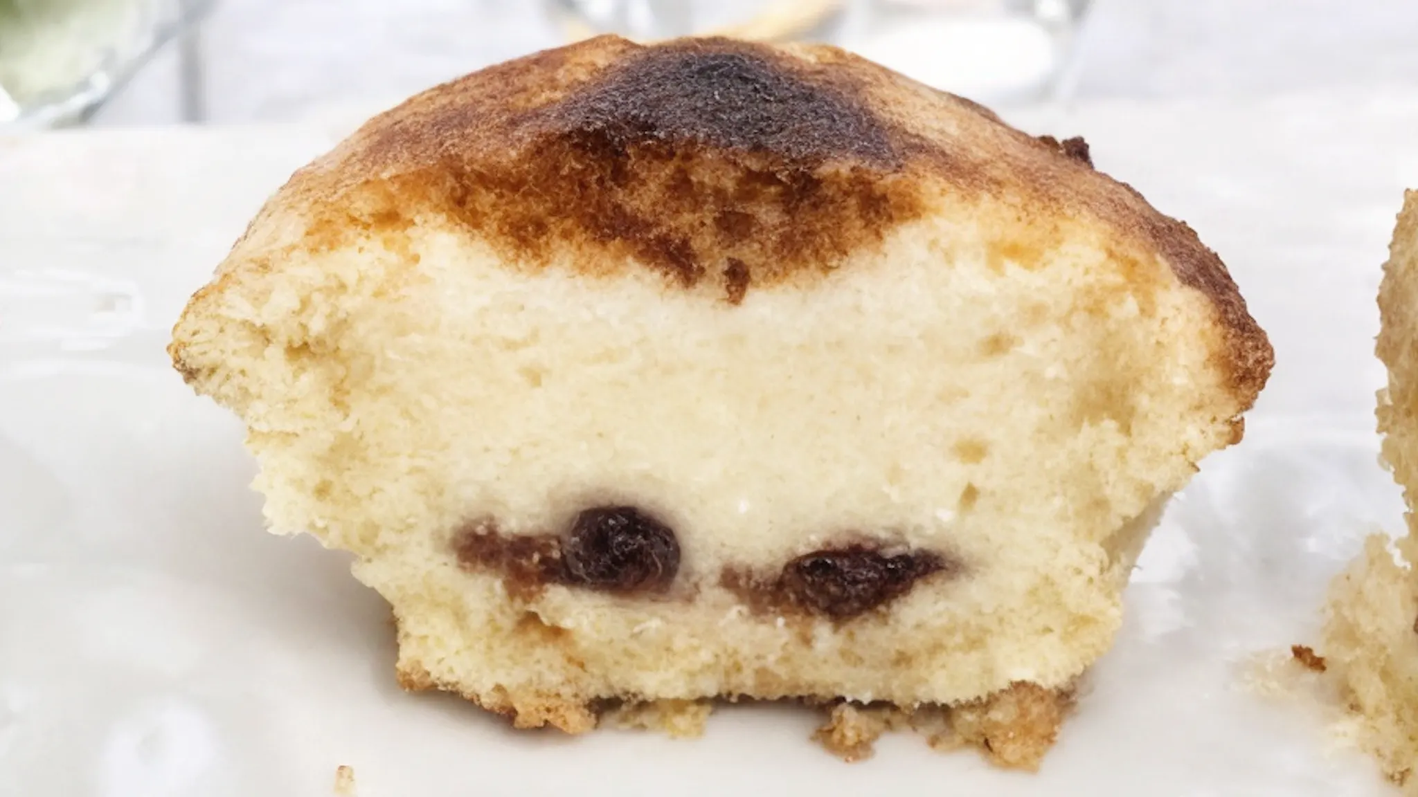 A Neapolitan pasticciotto cut in half, revealing a rich custard cream filling with sour cherries