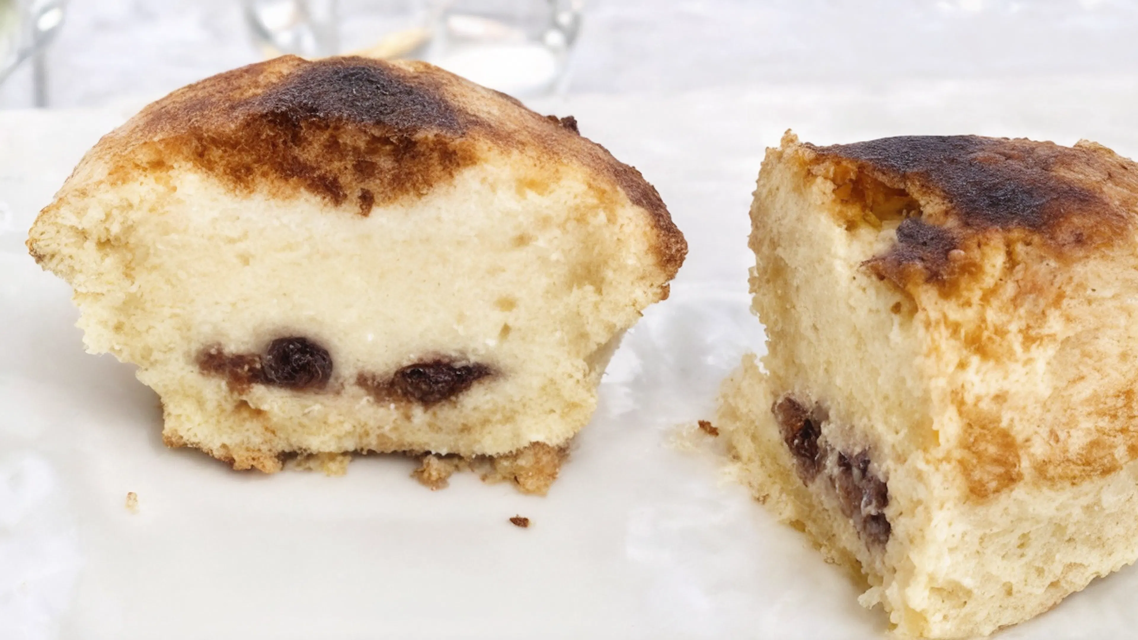 A Neapolitan pasticciotto cut in half, revealing a rich custard cream filling with sour cherries