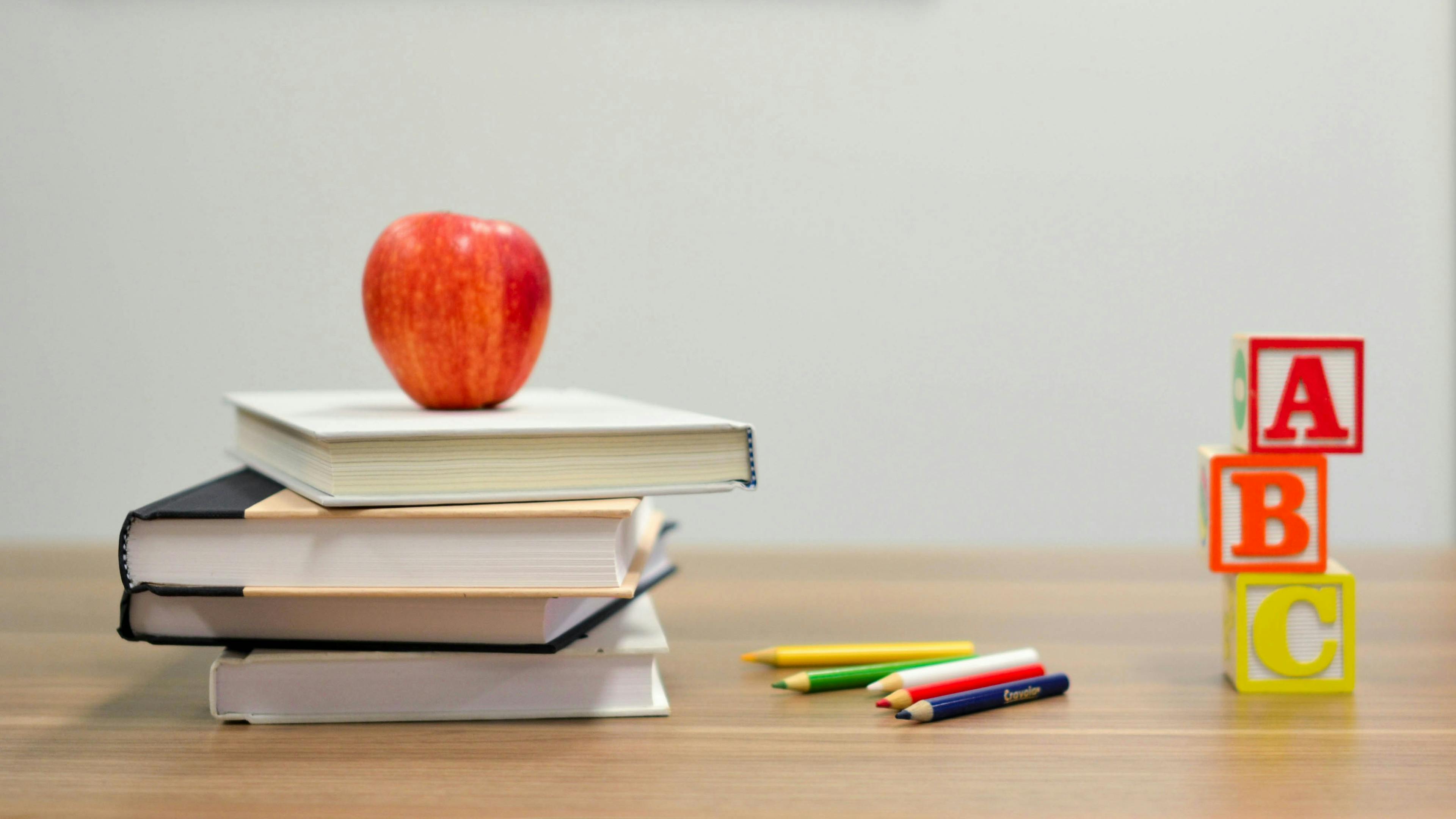 Back to school: books on the teacher’s desk with crayons
