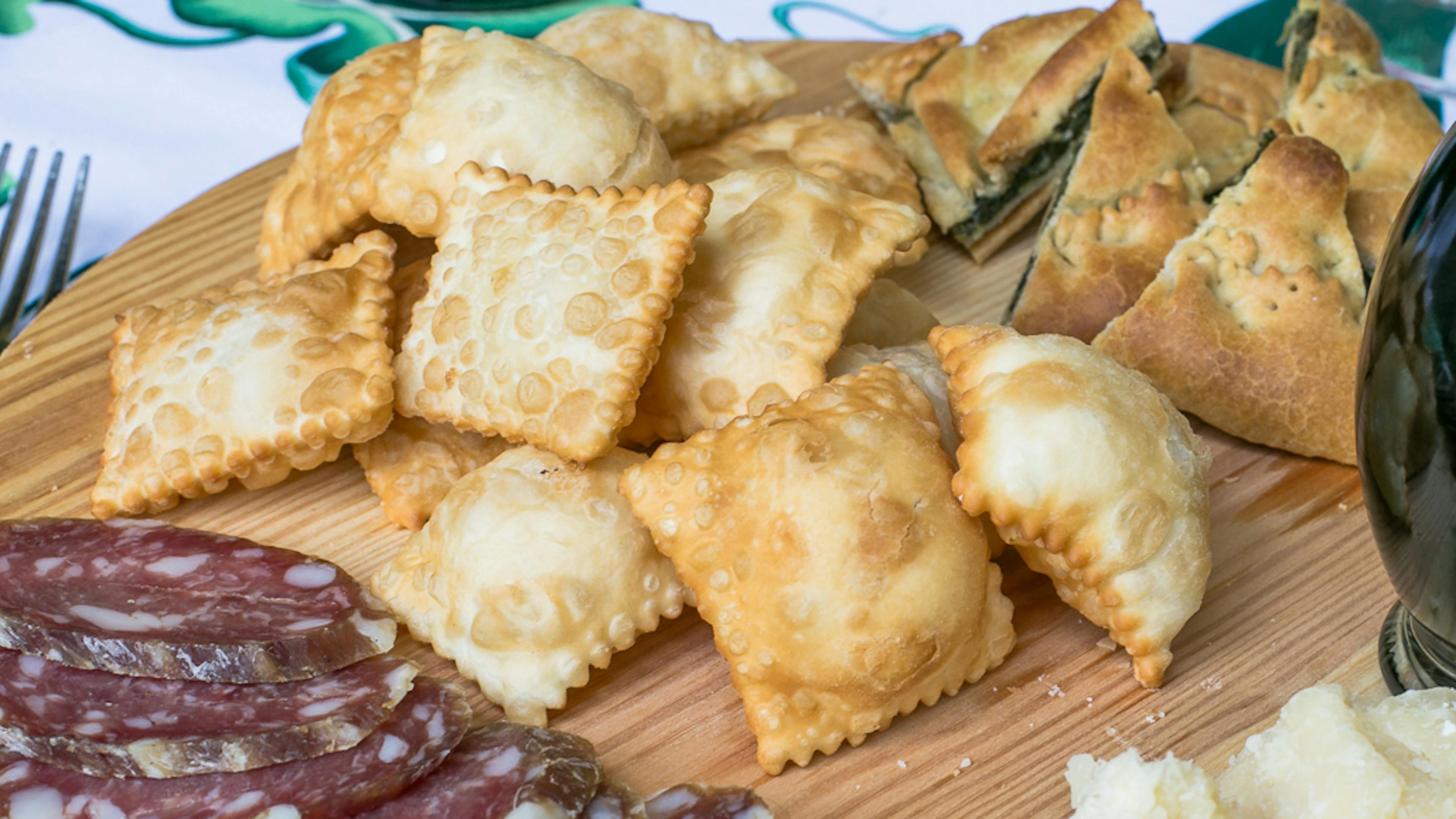 Cutting board with crescentine (fried dough), cold cuts and cheese